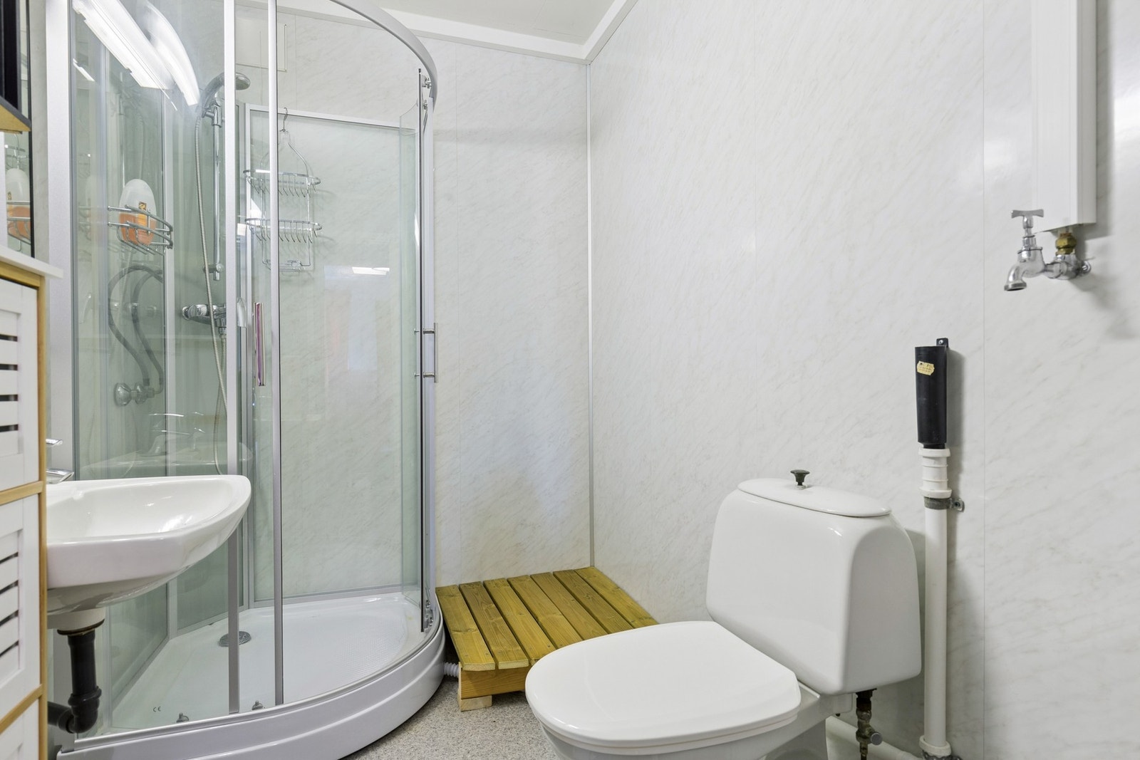 Badet har belegg på gulvet og plater på veggene. Galleribilde