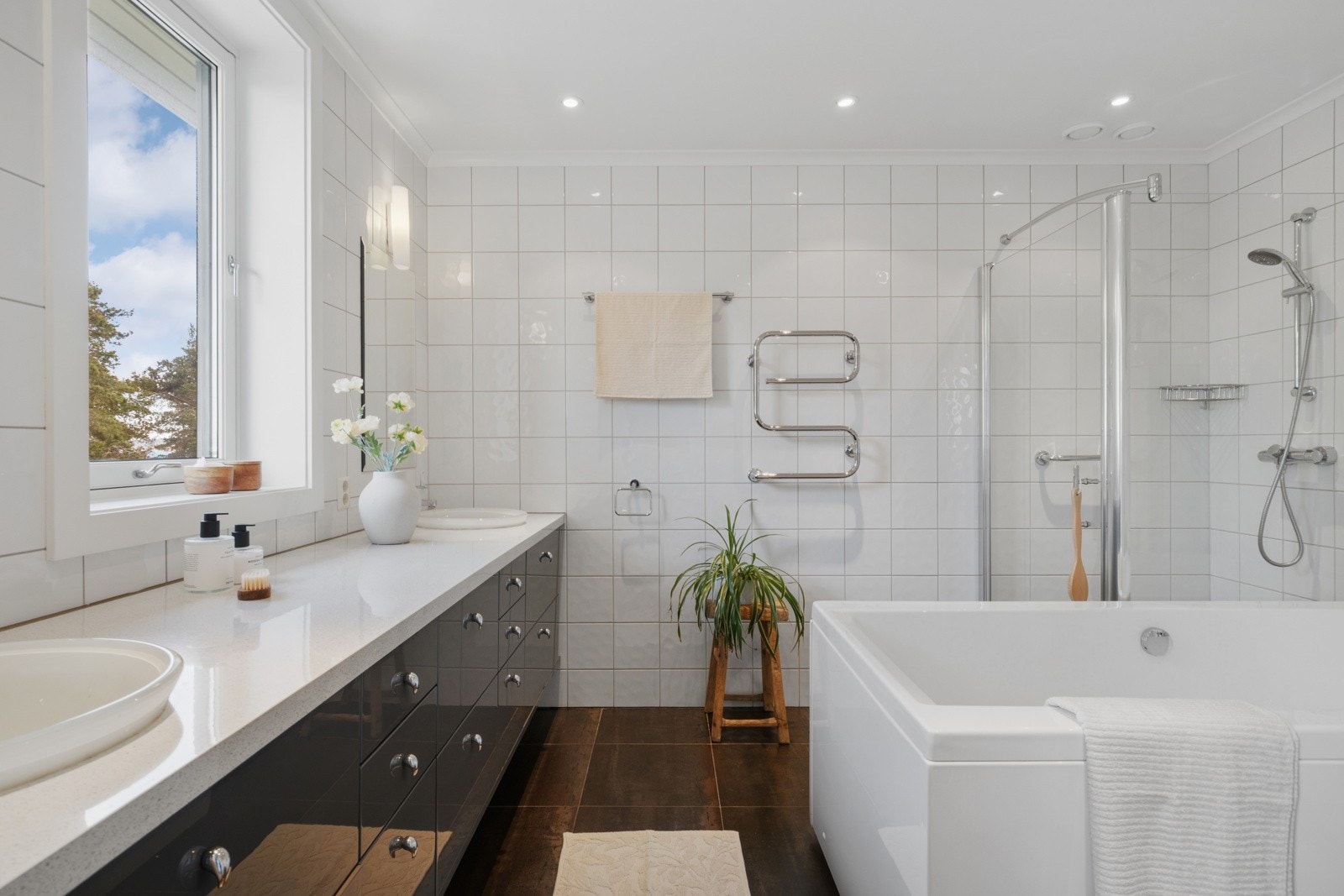 Dette badet har skyvedør inn fra hovedsoverommet, og er godt utstyrt med vegghengt toalett, et lekkert baderomsmøblement, dusjhjørne og badekar. Galleribilde