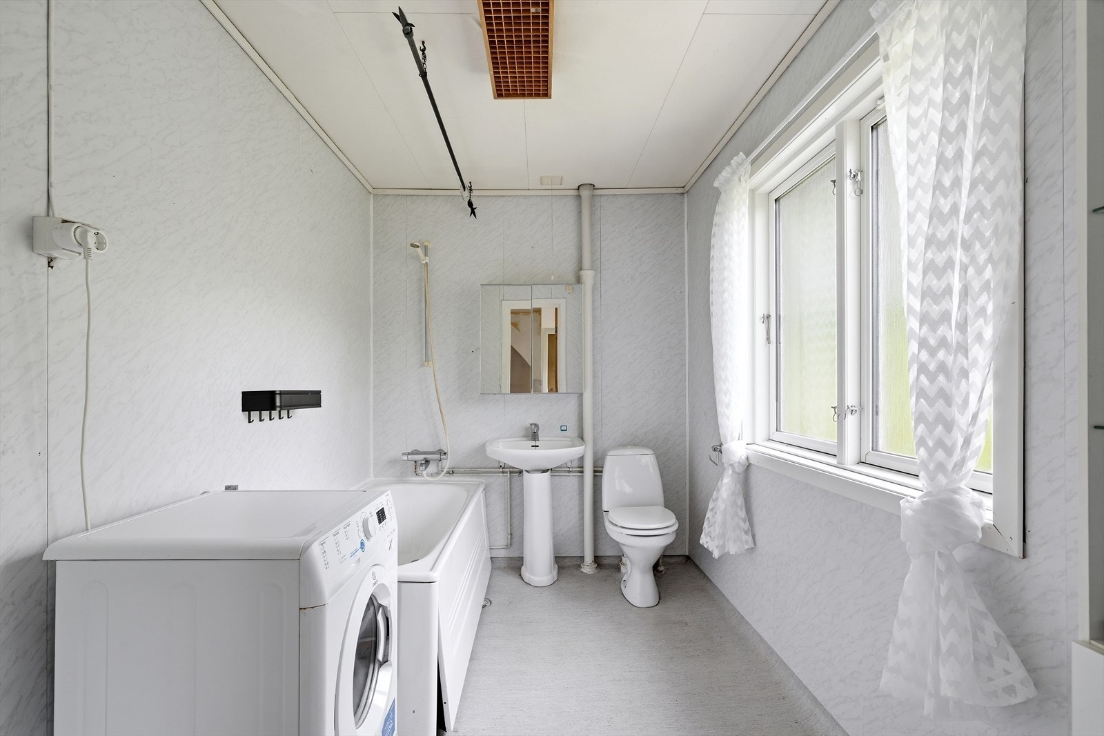 Badet er utstyrt med badekar, toalett, servant og har opplegg for vaskemaskin. Galleribilde