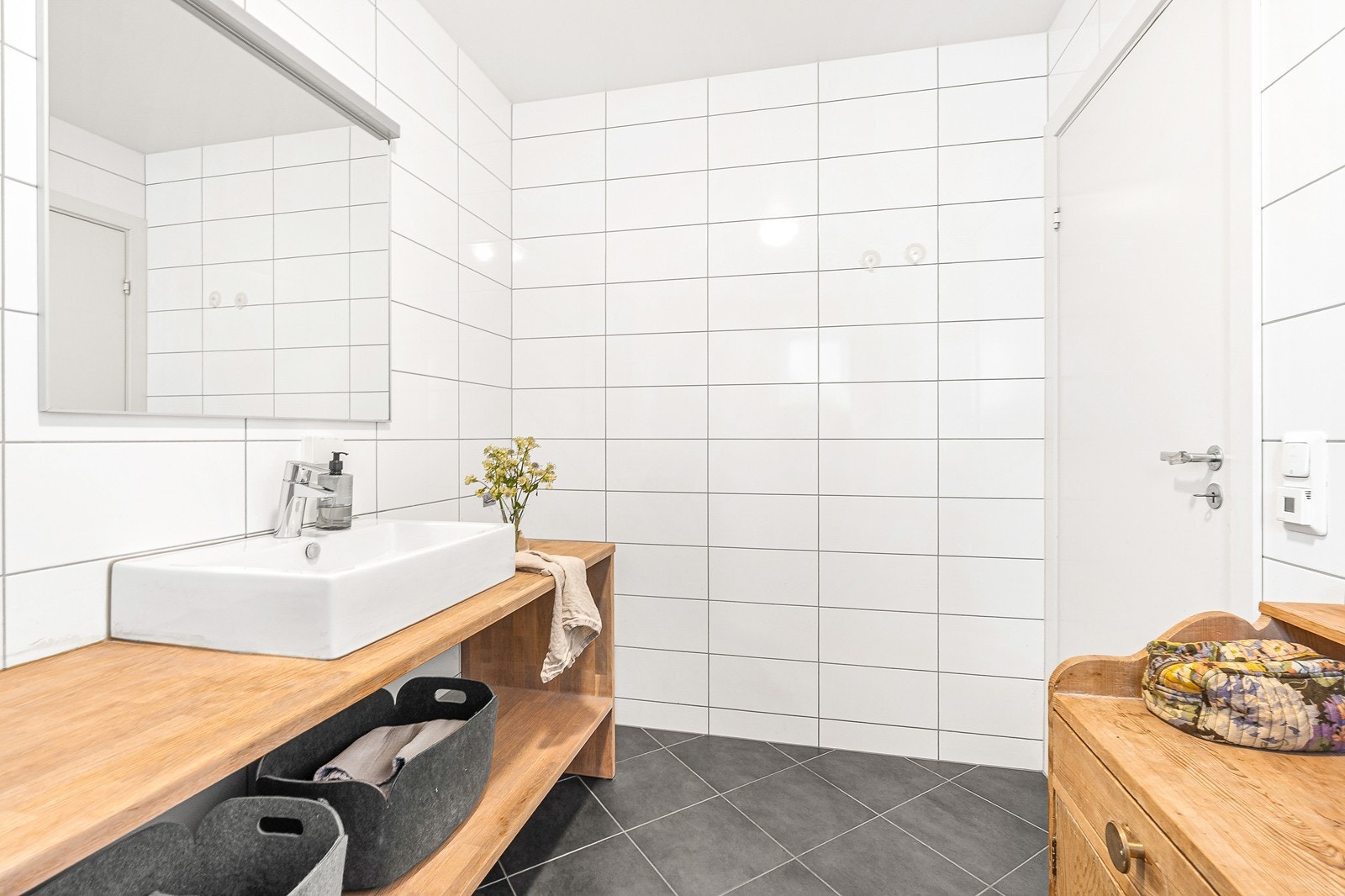 Badet er innredet med servant, speil, dusjhjørne, samt vegghengt toalett. Galleribilde