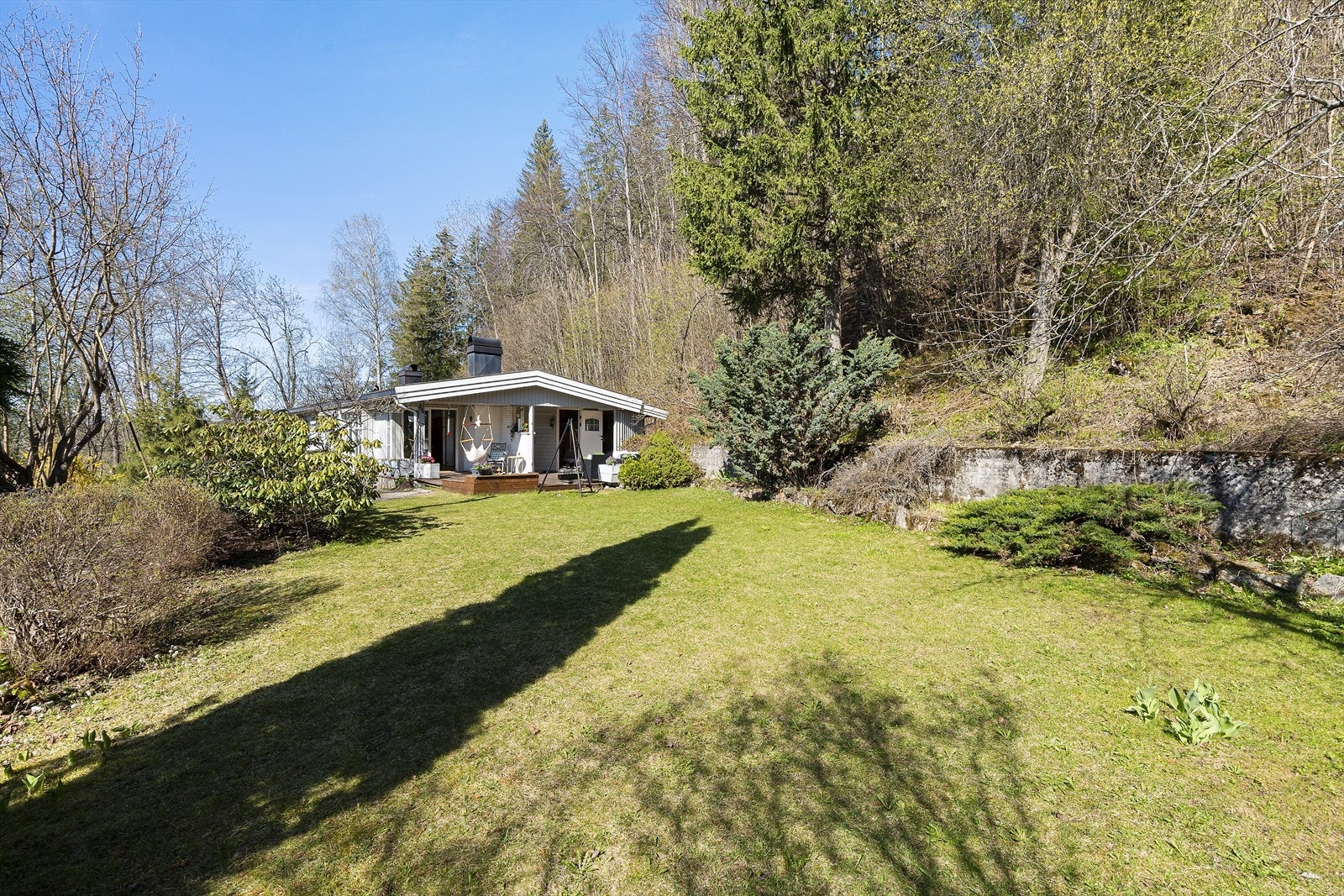 Den store tomten er opparbeidet med en romslig gressplen og diverse beplantning. Galleribilde