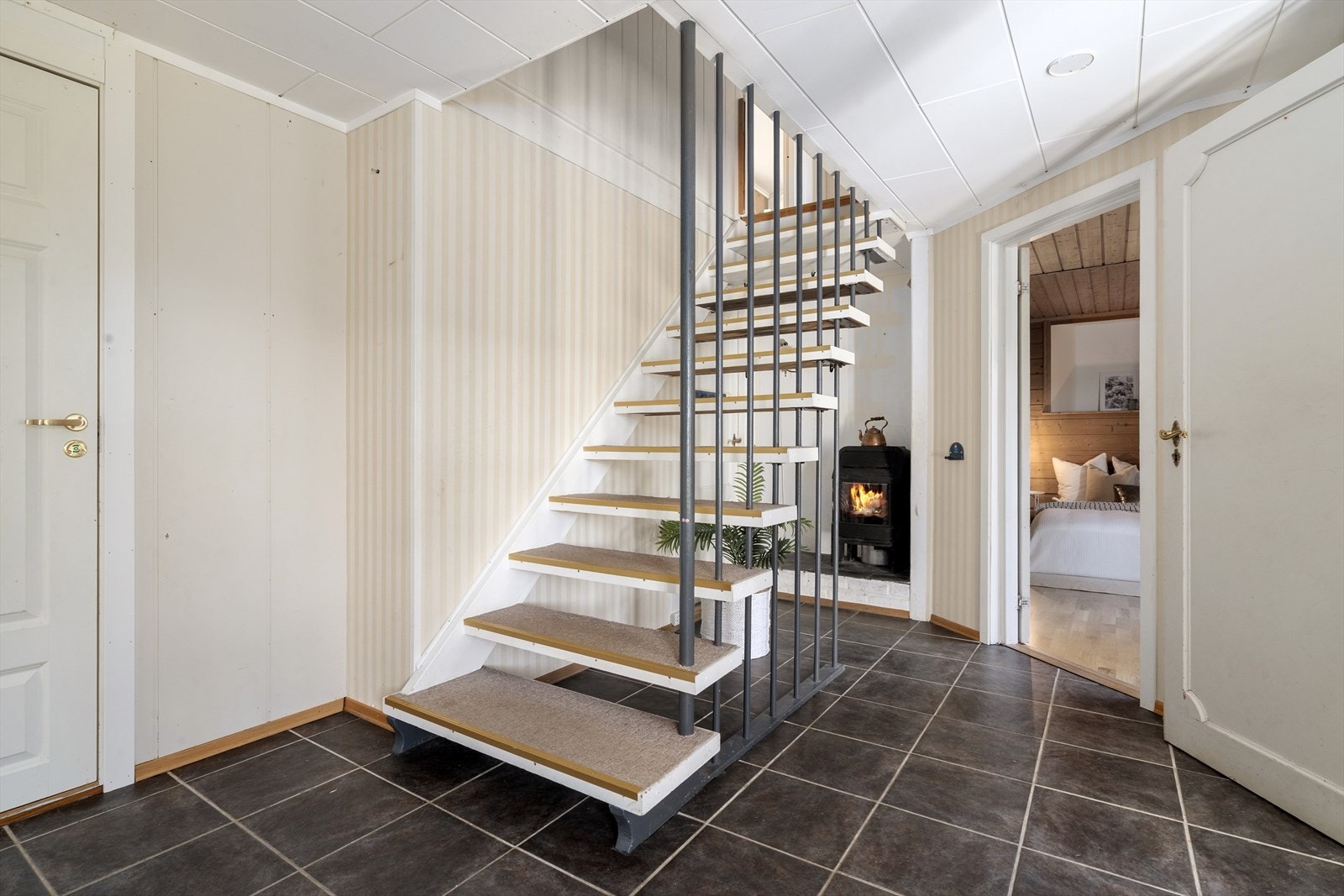 Den malte tretrappen med teppe i trinnene forbinder de to etasjene. Galleribilde
