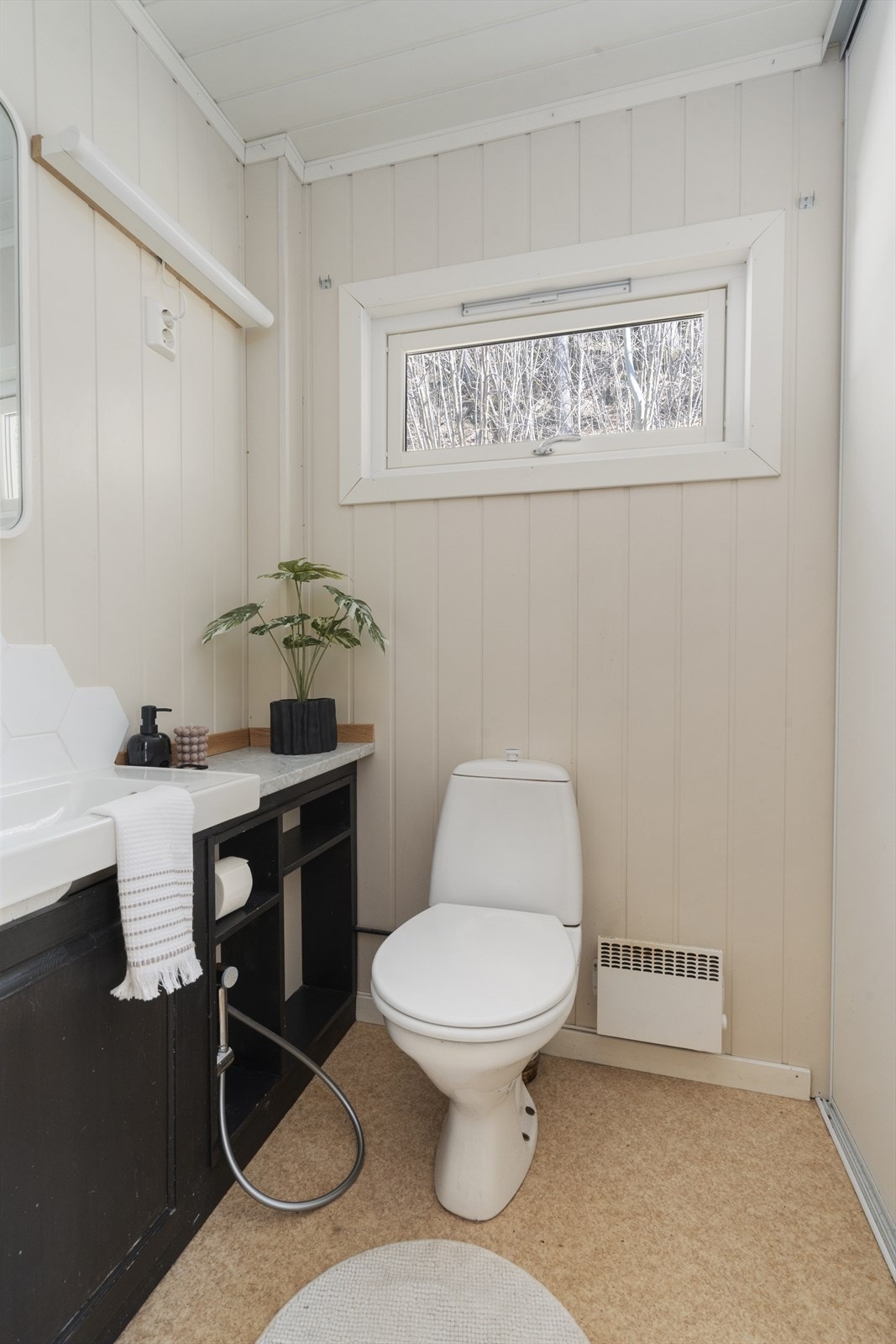 Separat toalettrom med servant og en praktisk skyvedørsgarderobe for ekstra oppbevaring. Galleribilde