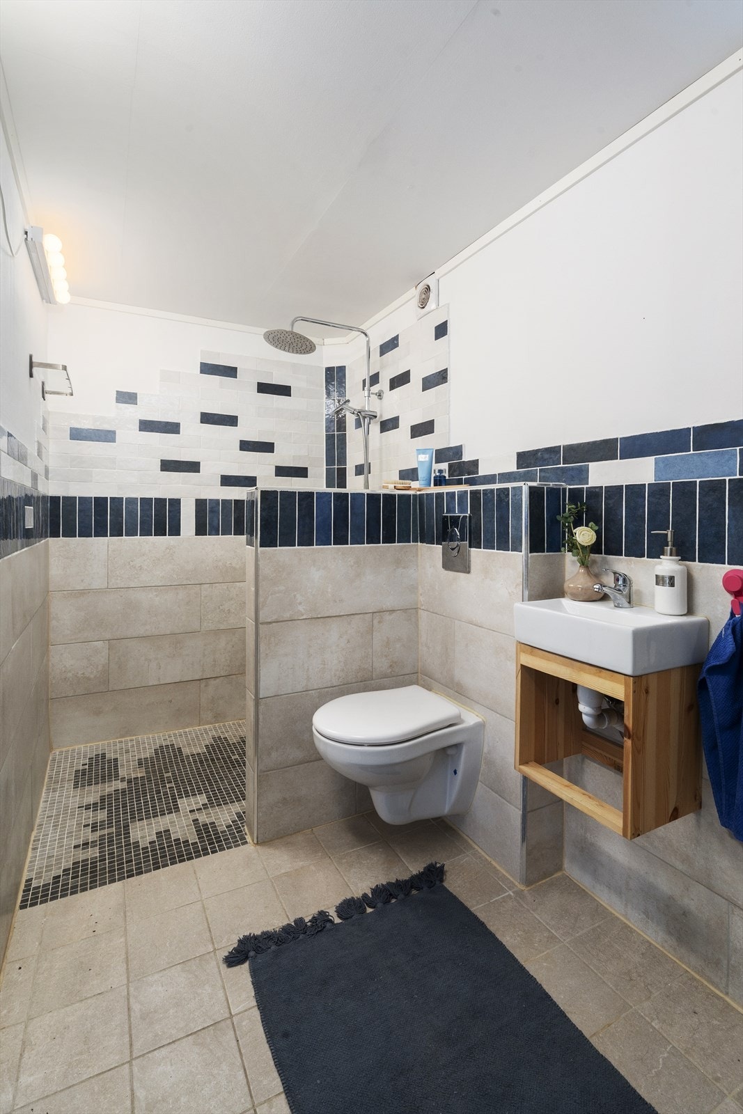 Badet er utstyrt med vegghengt toalett, dusjnisje og servant. Galleribilde