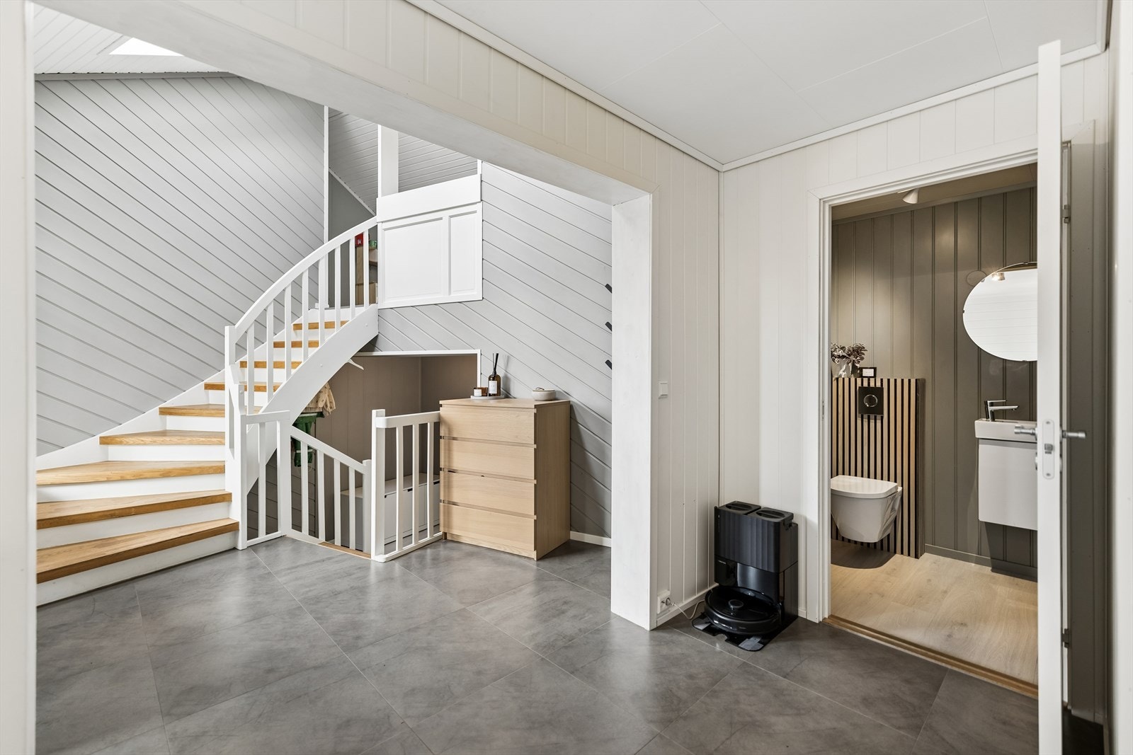 Entréen ønsker velkommen med flislagt gulv og varmekabler. Herfra leder trappen til de øvrige etasjene. Galleribilde