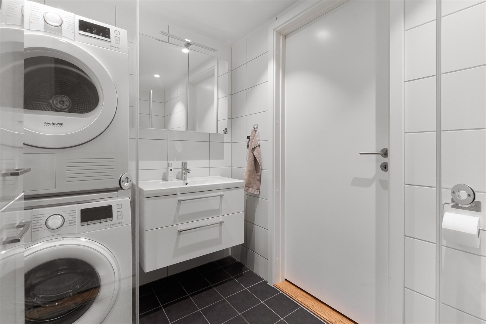 Badet har flislagt gulv med varme, downlights og opplegg for vaskemaskin og tørketrommel Galleribilde