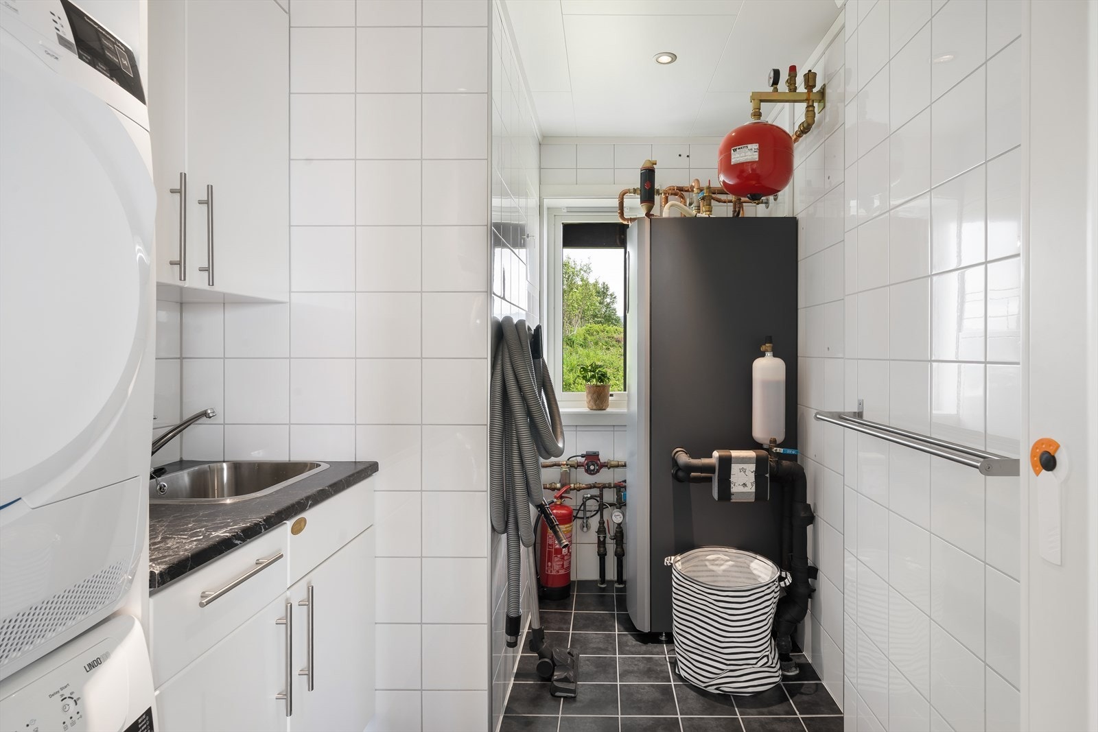 Det er montert en innredning i over- og underskap fra Møbelkjøkken med laminert benkeplate, integrert uttrekkbart strykebrett og opplegg for vaskemaskin. Galleribilde