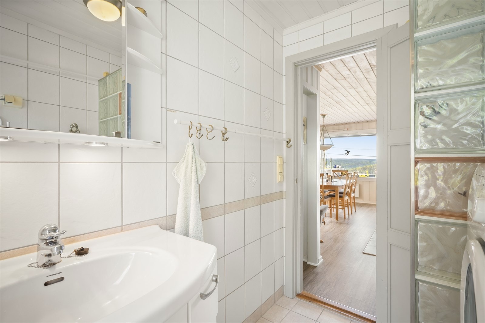 Badet har plass til vaskemaskin og praktiske oppbevaringsløsninger. Galleribilde