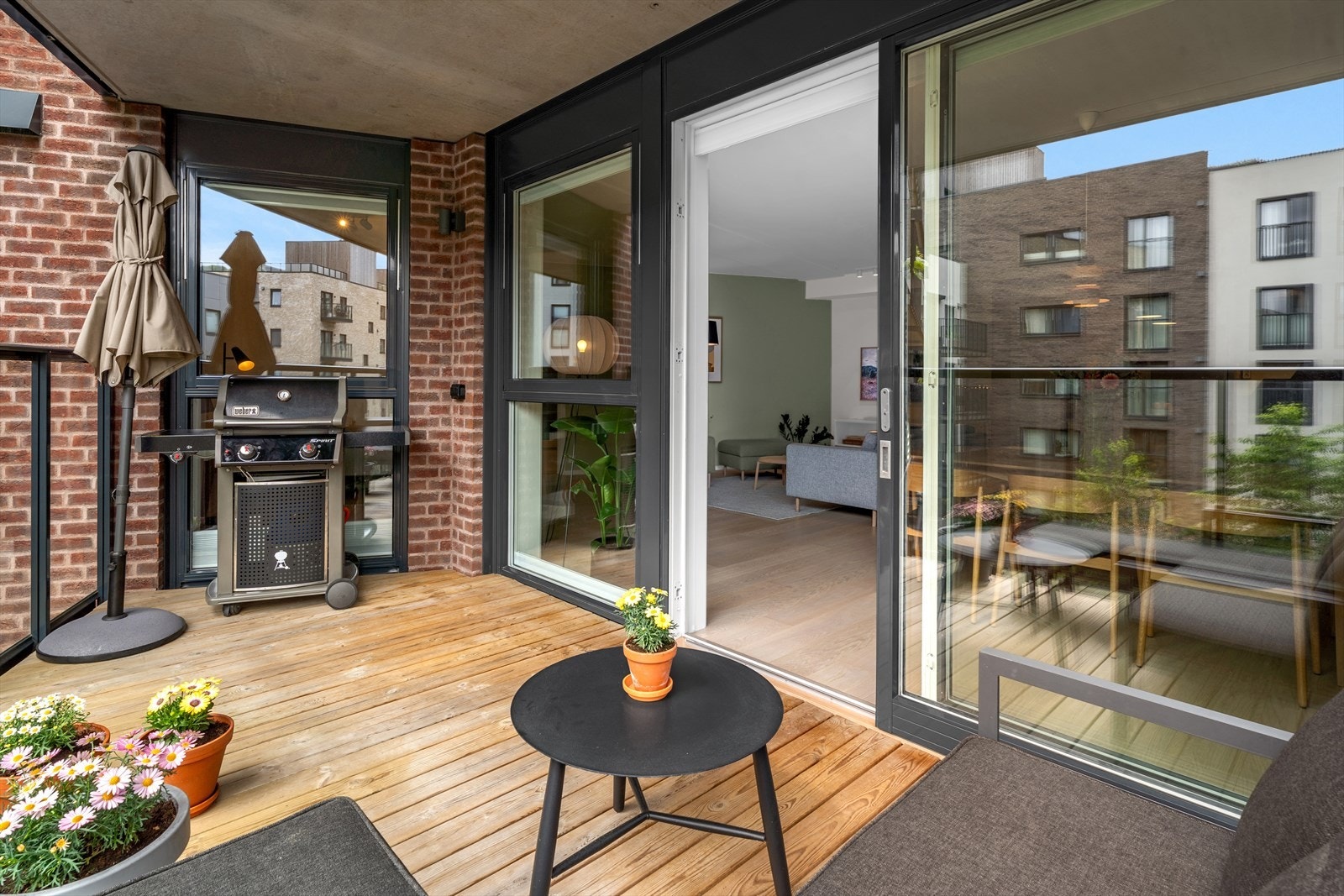 Balkongen fungerer som en forlengelse av stuen i sommerhalvåret med sitt overbygg og brede terrassedør. Galleribilde