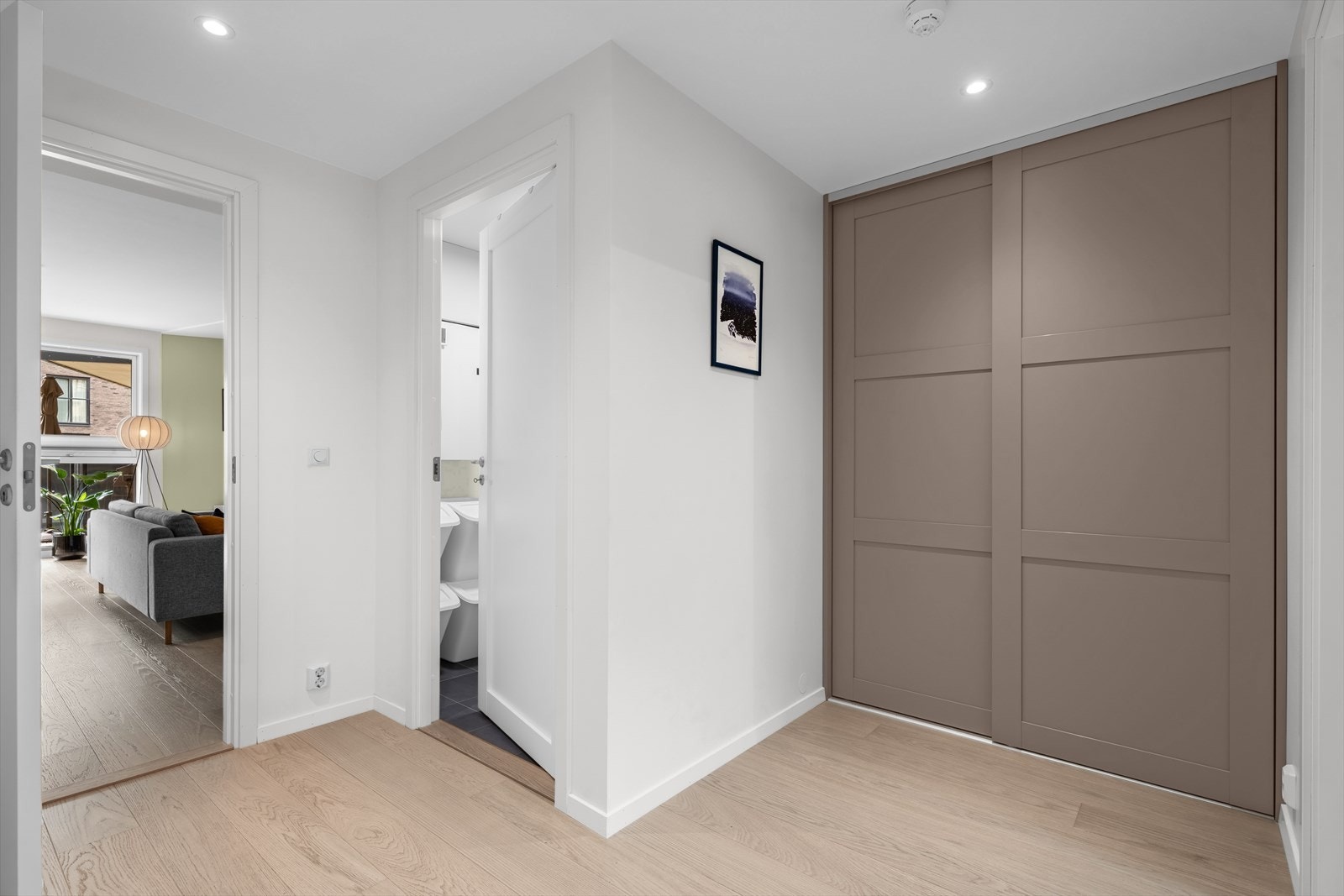 Mellomgang med plassbygget skyvedørsgarderobe. Galleribilde