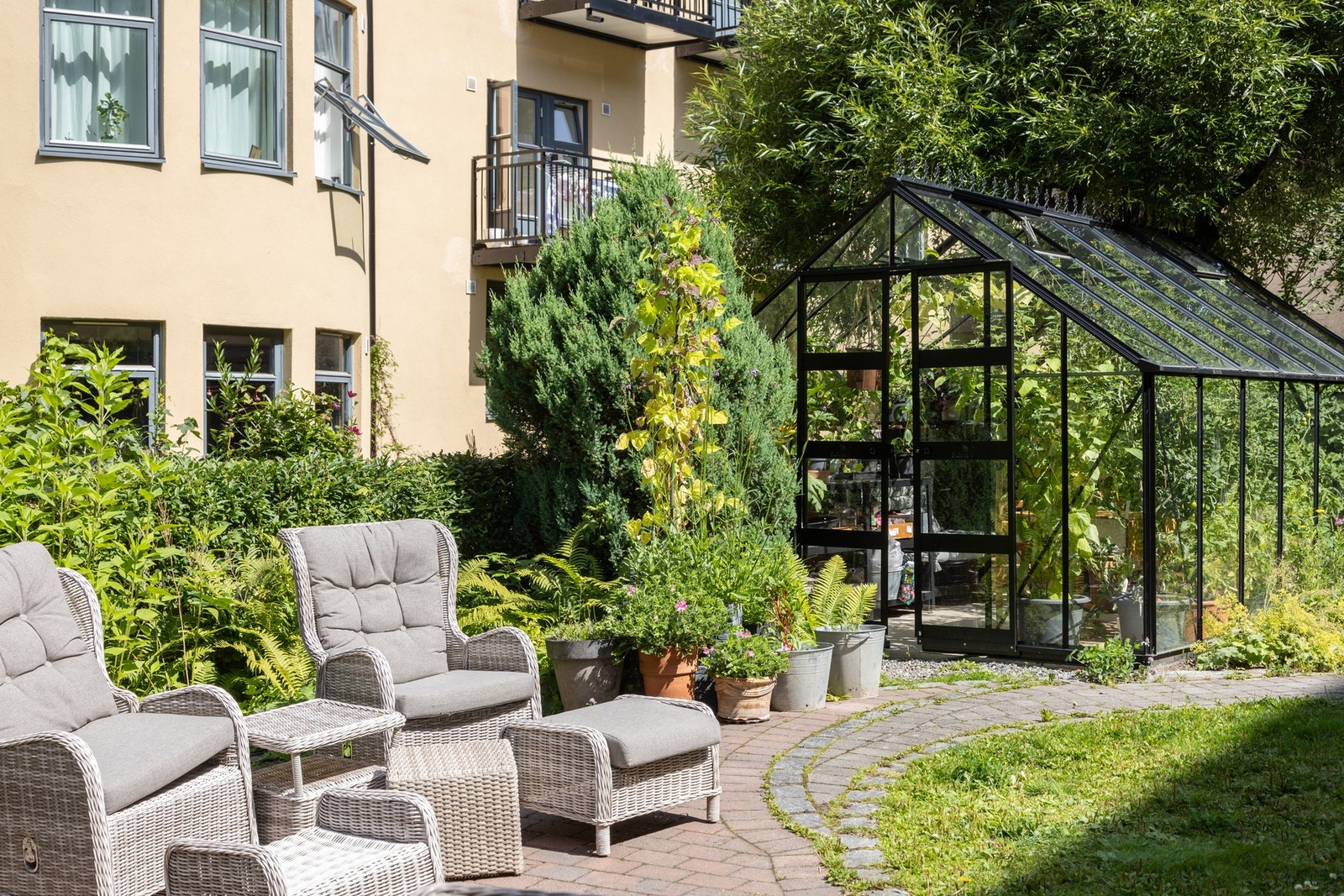 Boligen har tilgang til en hyggelig felles bakgård. Her er det satt opp hagemøbler, samt drivhus med vekster og beplanting. Galleribilde