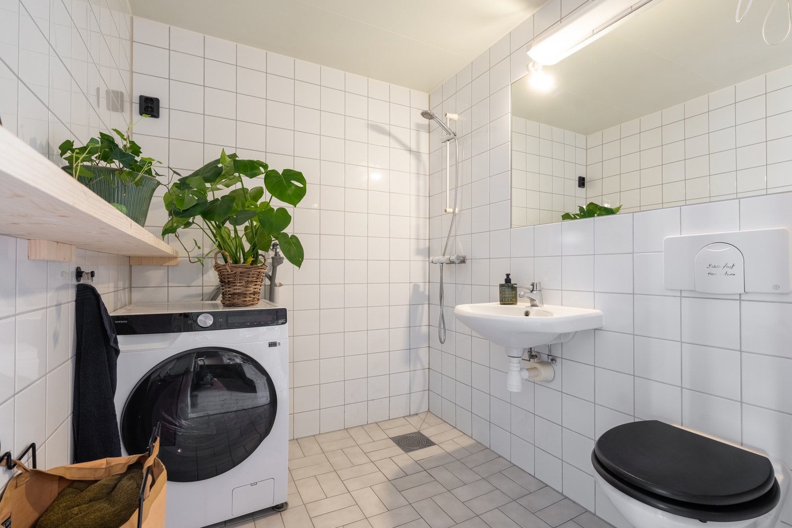 Badet er innredet med servant, innmurt speil med overbelysning, dusjhjørne og vegghengt toalett. Galleribilde