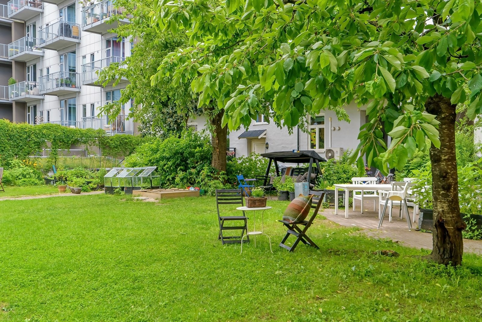 Hyggelig og idyllisk bakgård med sitteplasser, grill og mulighet for dyrking av urter og grønnsaker i felles blomsterkasser/drivhus. Galleribilde