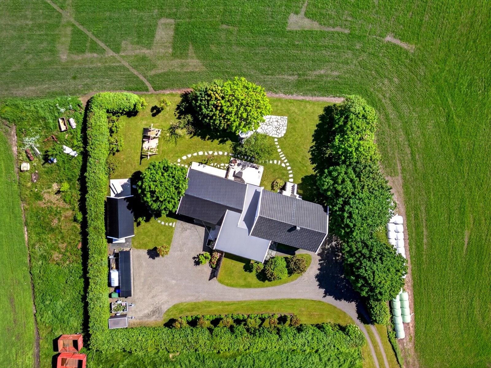 Tomten er meget pent opparbeidet med gresslagte områder, skiferlagte stier, beplantning, busker og trær. Galleribilde