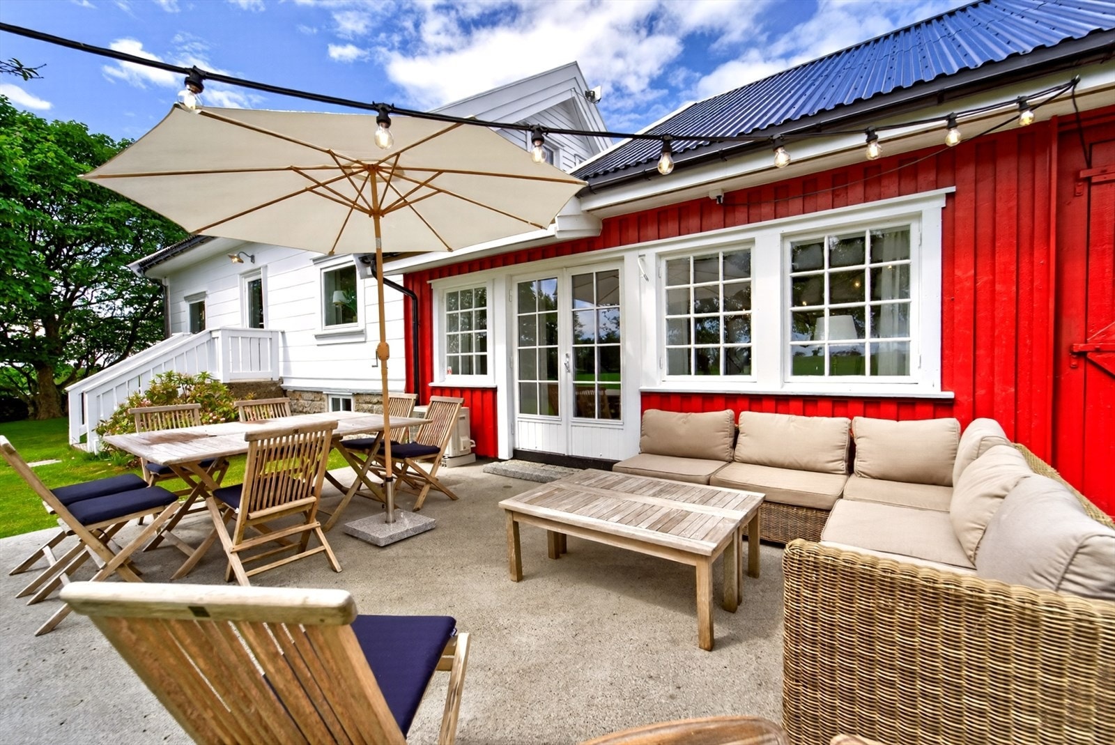 Stor og solrik uteplass med god plass til både spisegruppe og loungemøbler - perfekt for lange sommerdager og hyggelige sammenkomster i landlige omgivelser. Galleribilde