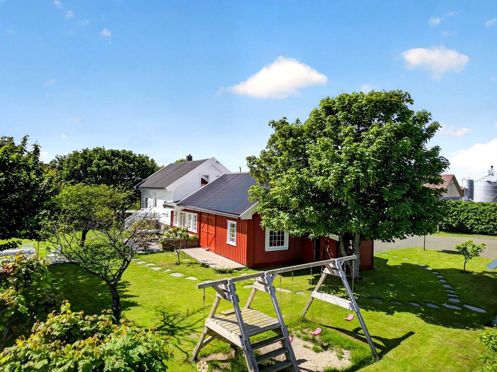 Idyllisk og romslig uteområde med frodig hage, flere sitteplasser og gode arealer for lek og rekreasjon. Galleribilde