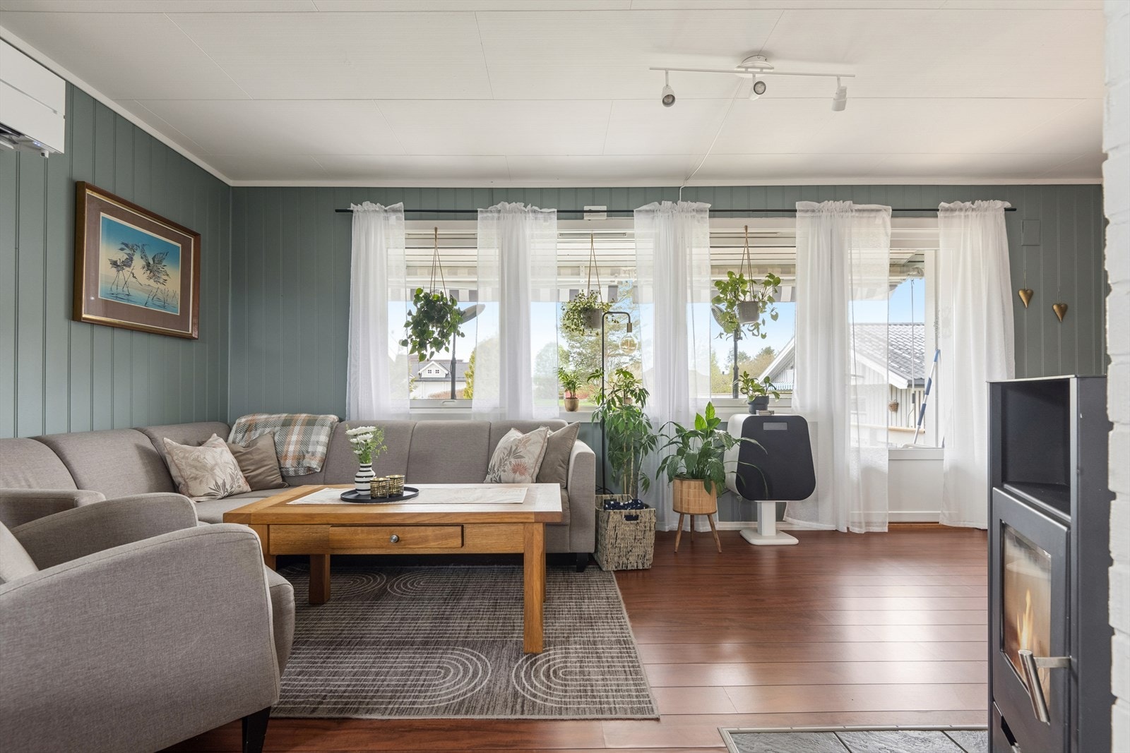 Stuen har plass til en romslig sofagruppe og får lys fra flere vinduer. Galleribilde