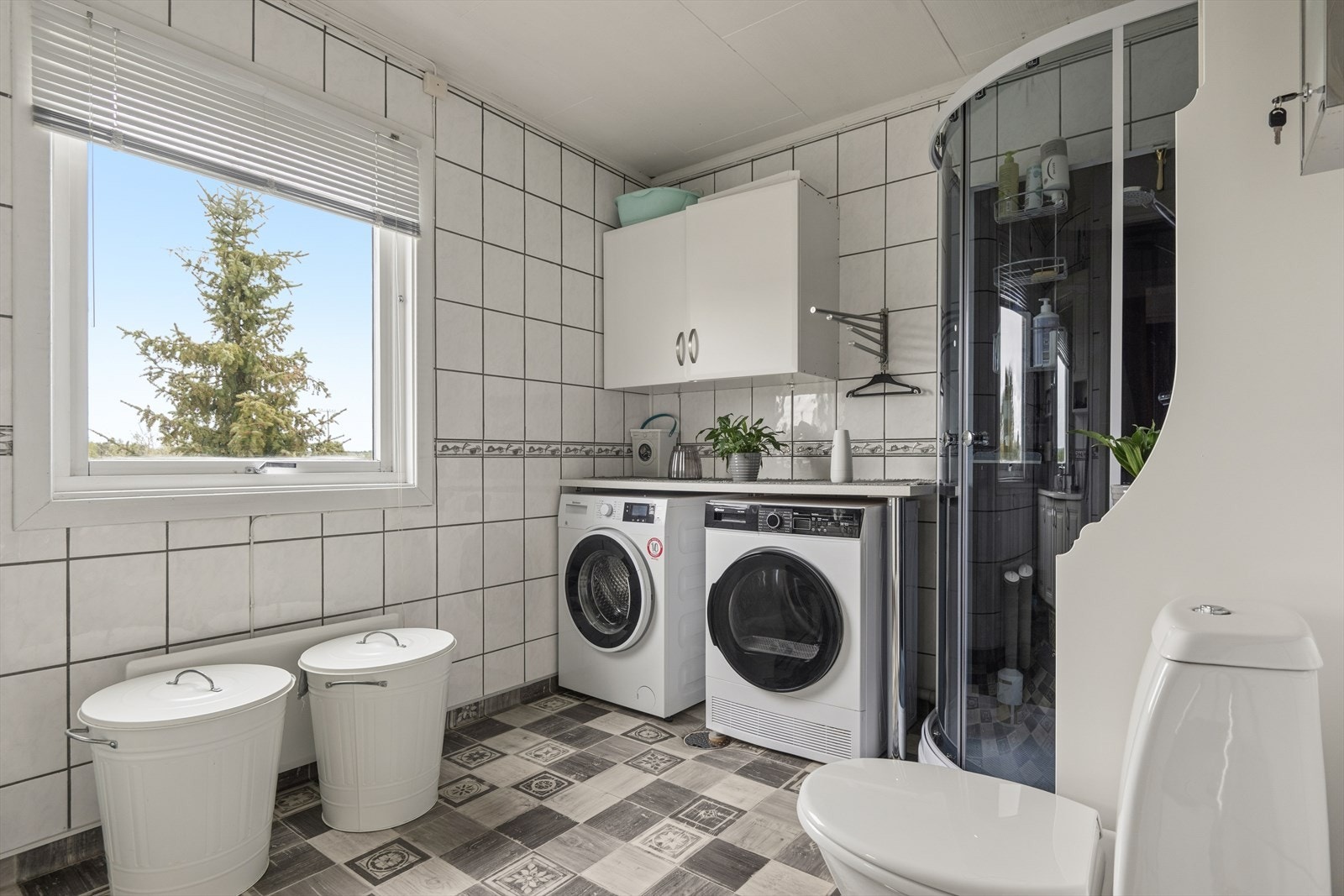 Badet har vinylbelegg på gulv, keramiske fliser på veggene og opplegg for vaskemaskin. Galleribilde