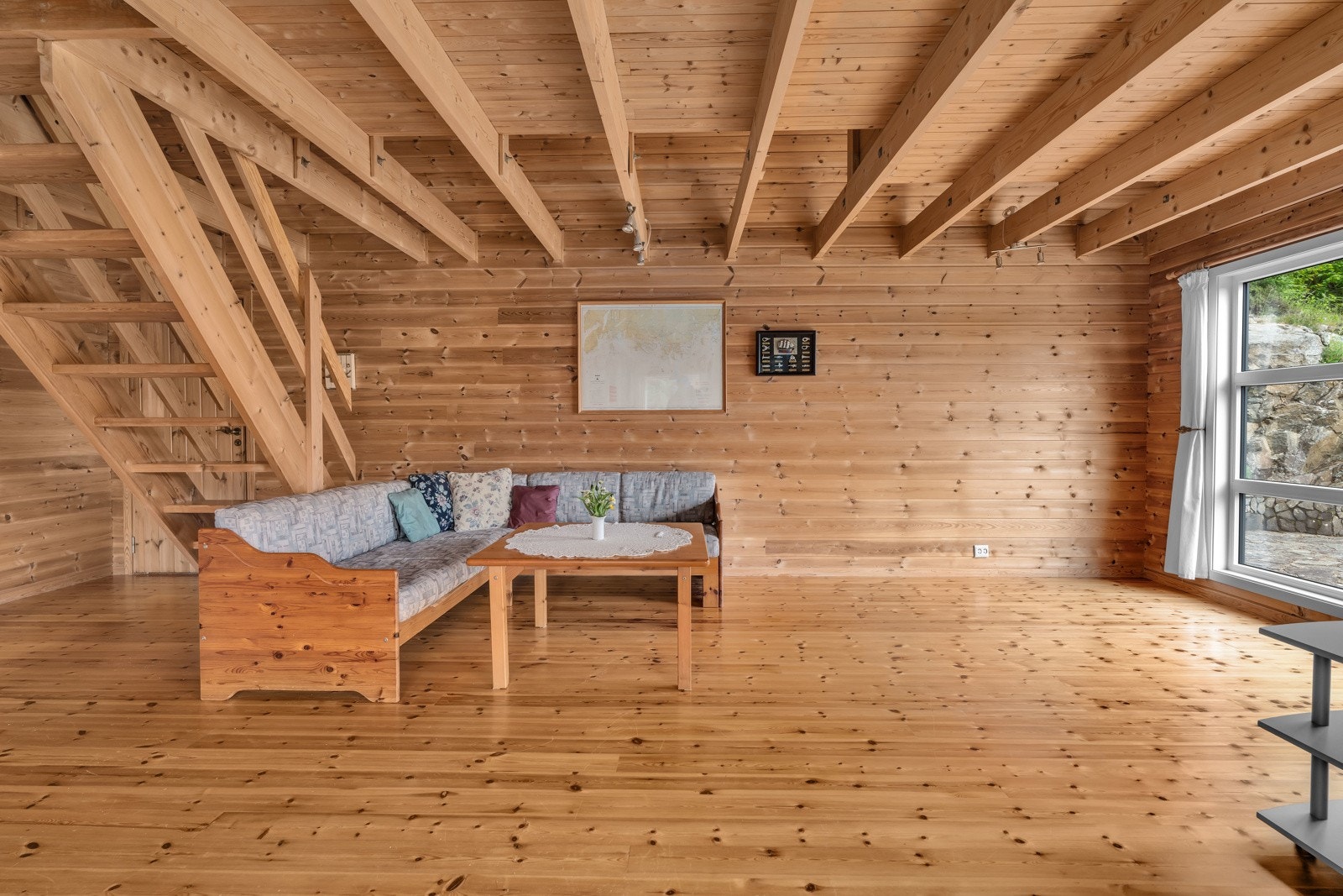 Romslig og lys stue med vindusflater som slipper inn godt med naturlig lys og delvis åpent bjelkelag som gir ekstra romfølelse. Galleribilde