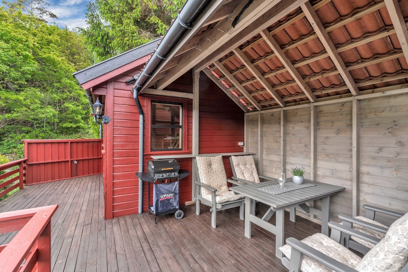 Annekset har en fin plassering på terrassen med vindu med utsikt, og har halvtak og levegg som brukes til grillbu. Galleribilde