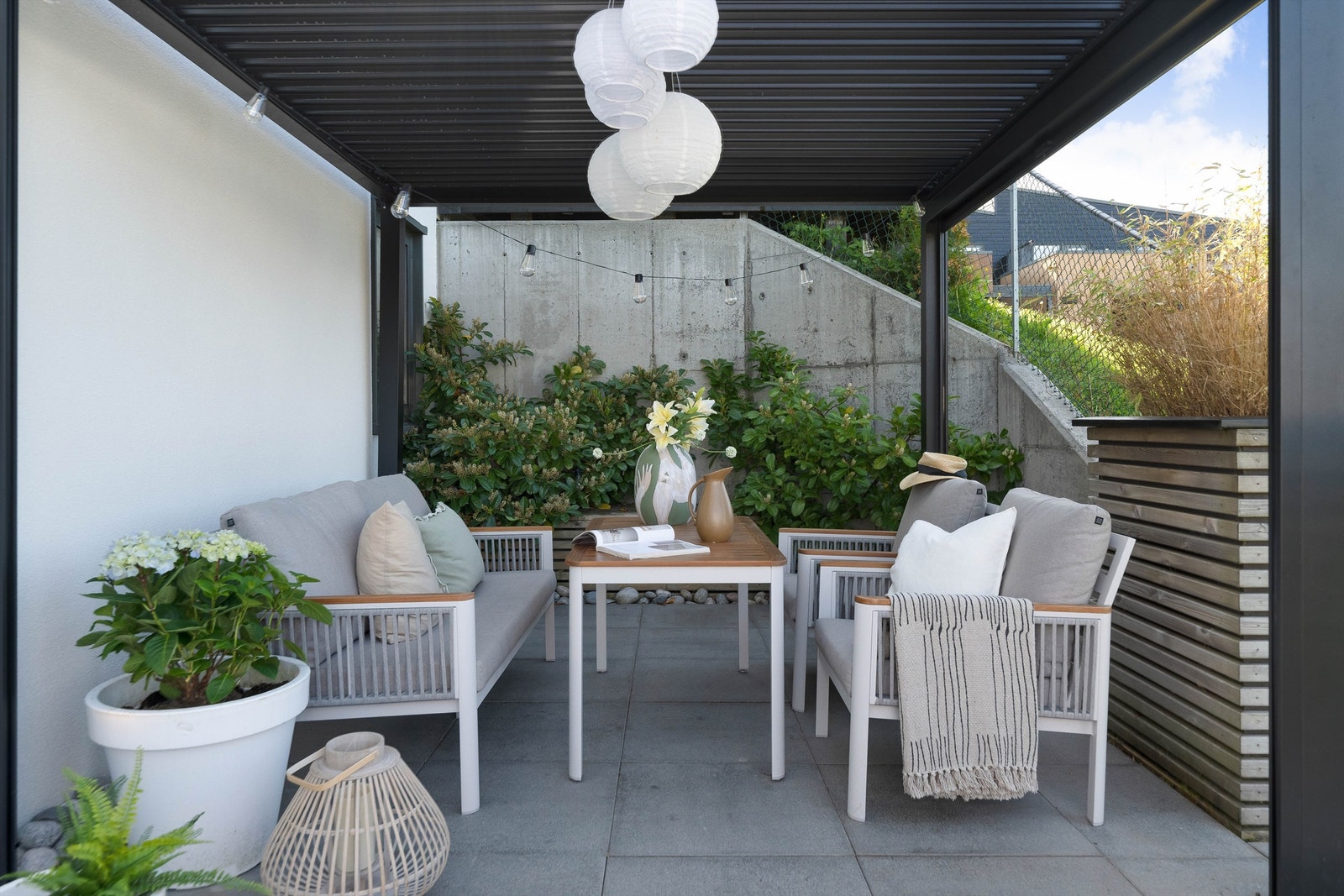 Nydelig uteplass på nedsiden av huset. Pent opparbeidet. De heller, pergola, blomsterkasser og terrassebord. Galleribilde