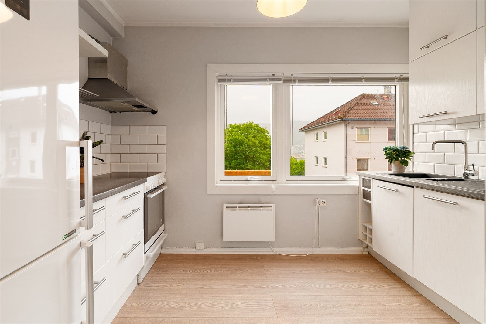 Kjøkkeninnredning med lyse glatte fronter og laminert benkeplate. Galleribilde