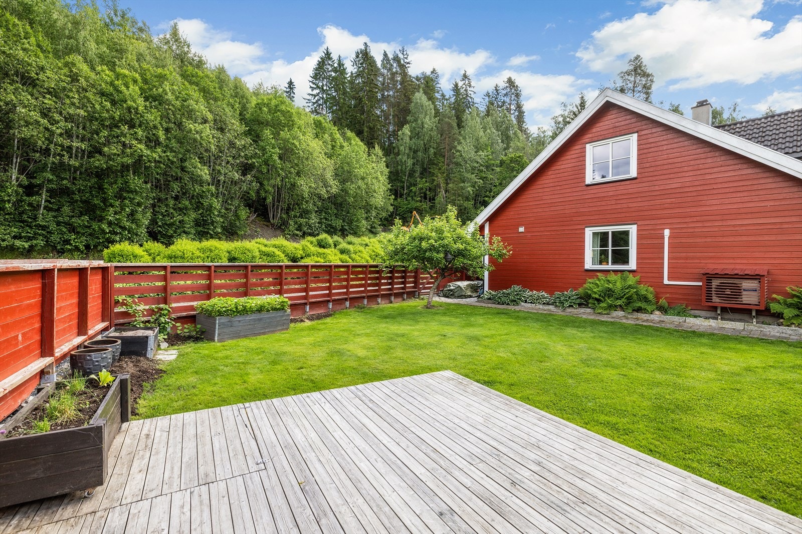 Hagen er opparbeidet med plen, blomsterbed og et frukttre, og er omkranset av hekk og gjerde. Galleribilde