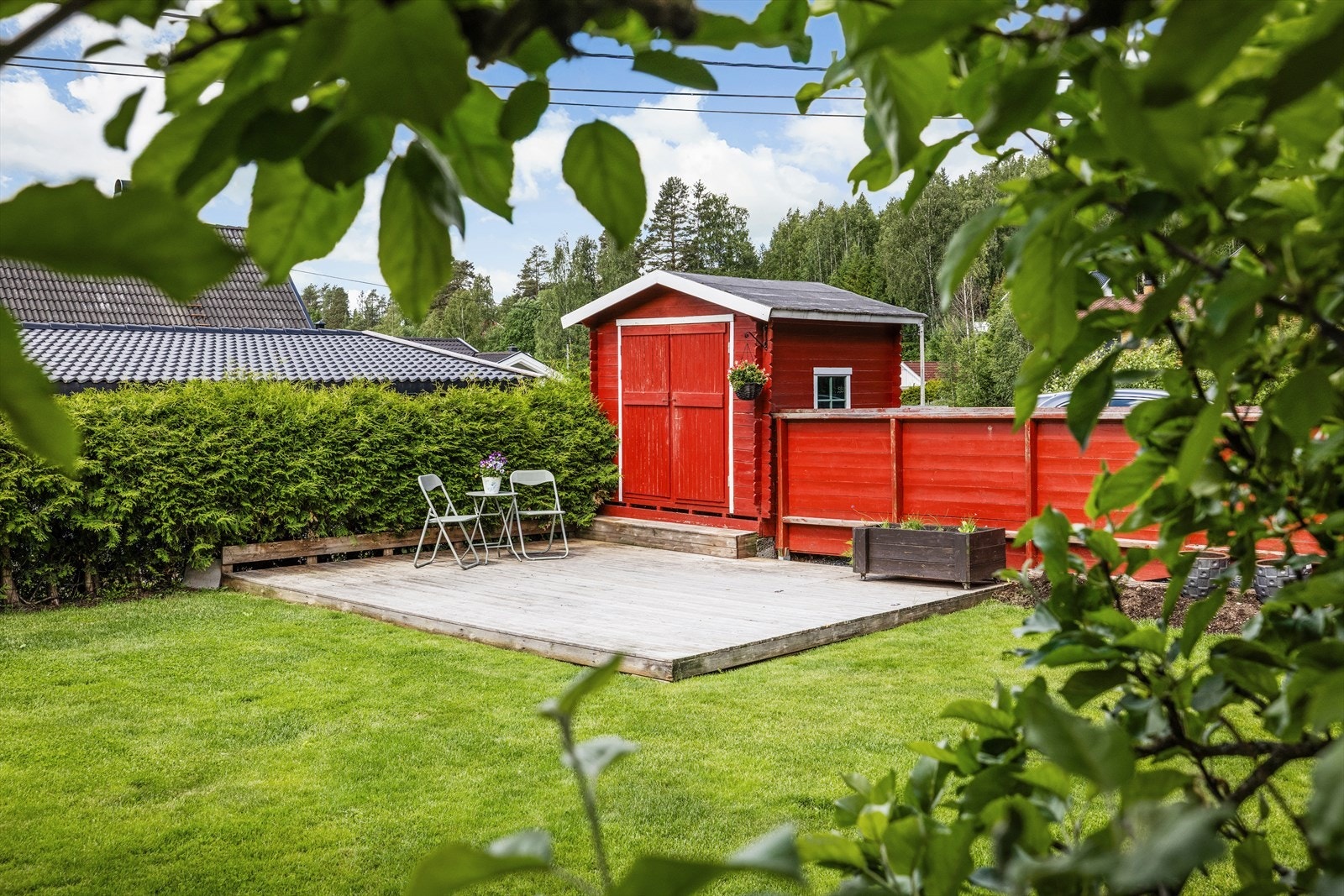 I hagen er det en terrasseplatting og et enkelt bodbygg av lafteplank for ekstra lagring. Galleribilde