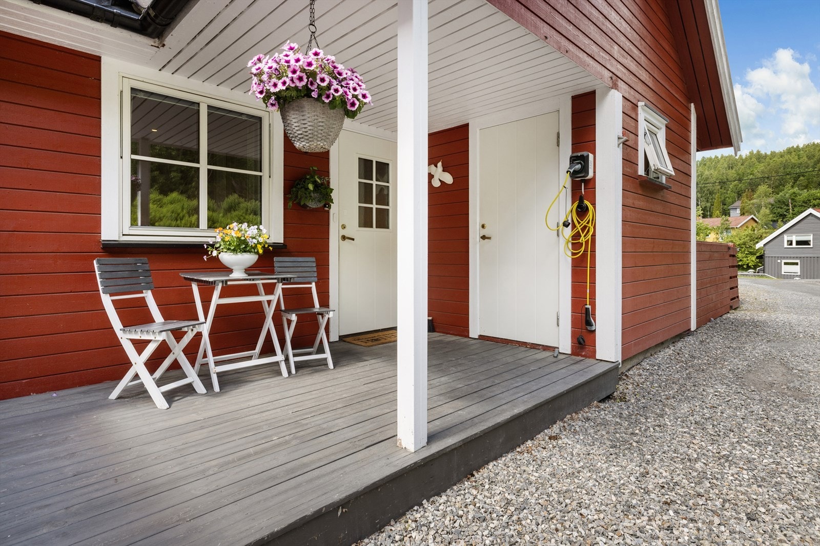 Ved inngangspartiet er det en delvis overbygget terrasseplatting. Her er det også montert elbil-lader. Galleribilde