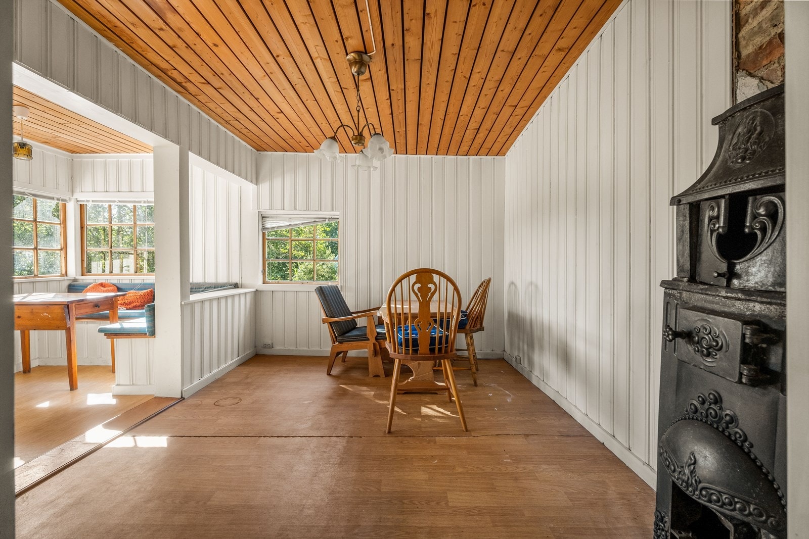 Rommet har malte panelvegger og vindu mot hagen. Galleribilde