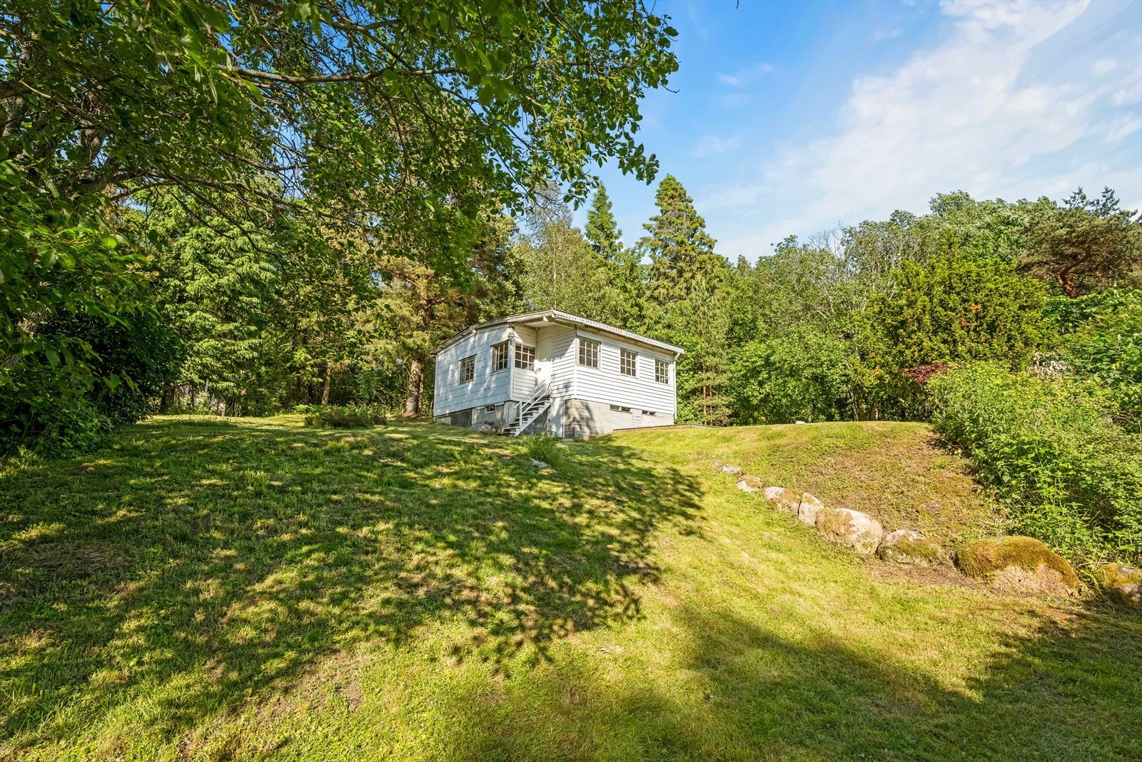 Eiendommen ligger tilbaketrukket til på en naturtomt, omkranset av skog. Galleribilde