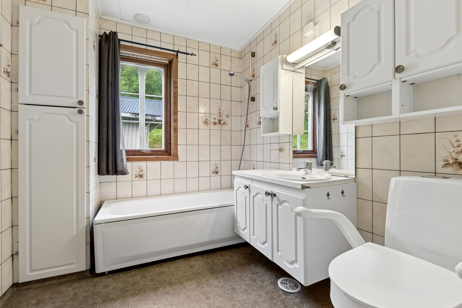 Badet i hovedetasjen inneholder badekar, toalett og servant med oppbevaring. Galleribilde