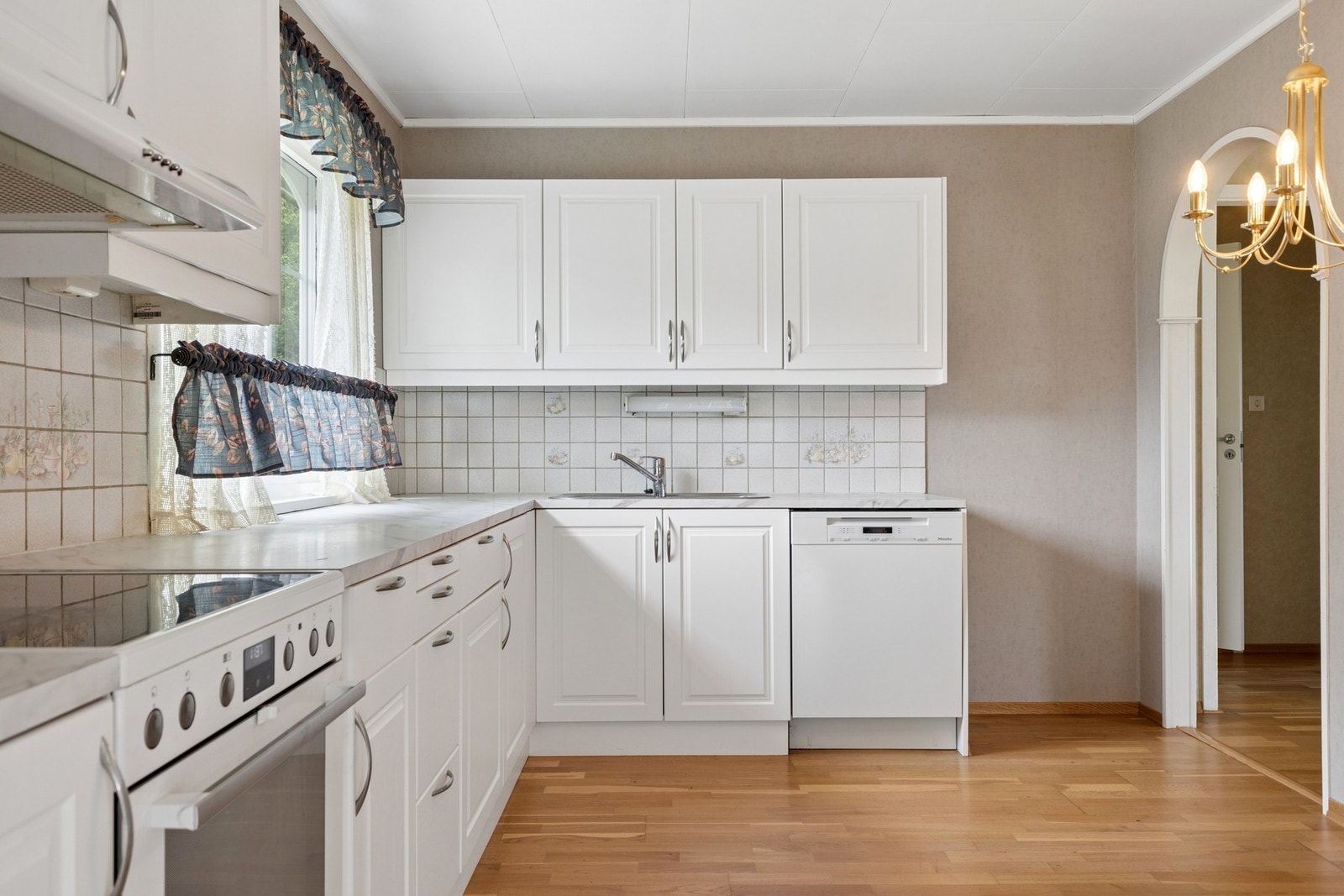 Kjøkkeninnredningen har profilerte fronter og laminat benkeplate. Galleribilde