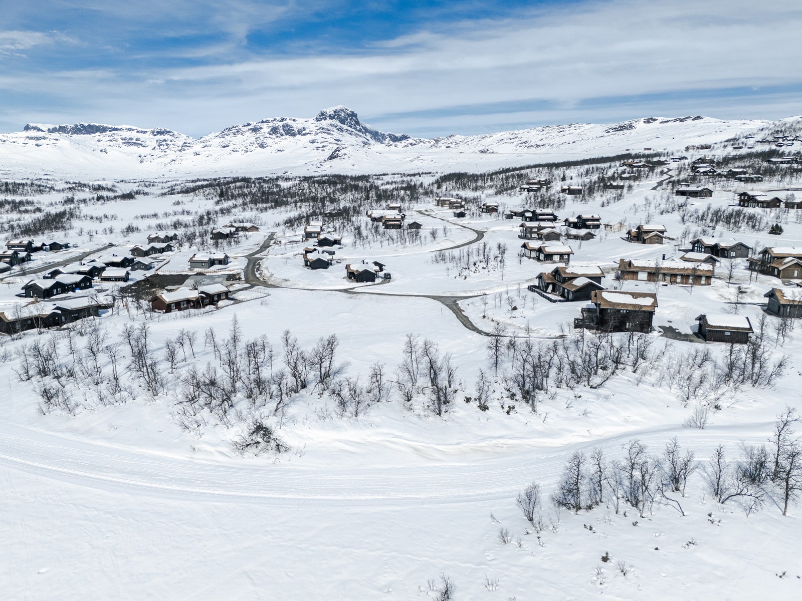 Et eksklusivt og helhetlig nabolag. Strenge estetiske retningslinjer for området, som krav til torvtak, naturstein og avdempede jordfarger, sikrer at hyttene glir vakkert inn i det storslåtte fjellandskapet Galleribilde