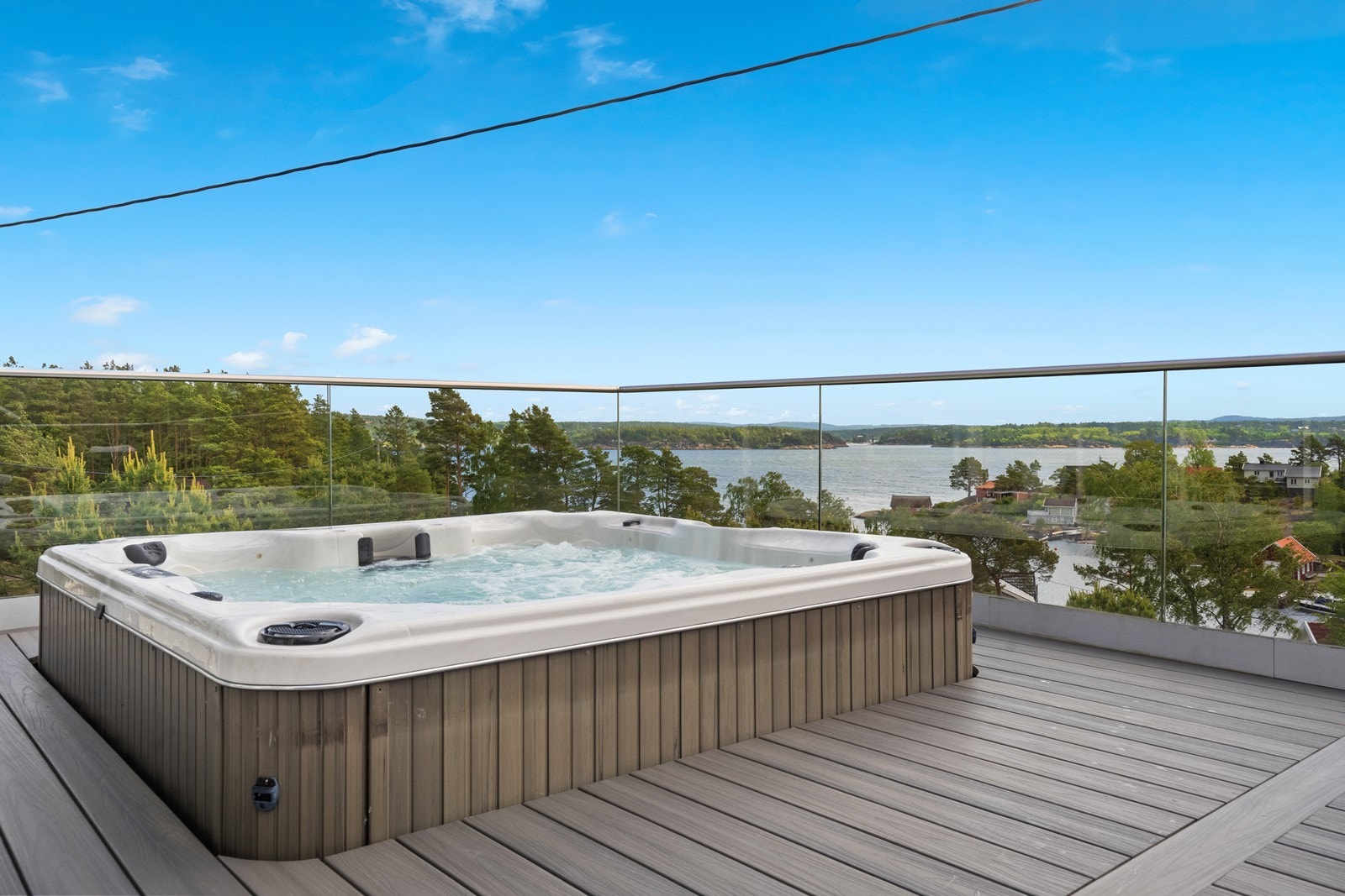 I hjørnet på verandaen er det jacuzzi, halvveis nedfelt i verandaen - Glassrekkverket gjør at man kan nyte utsikten selv i fra jacuzzien. Galleribilde
