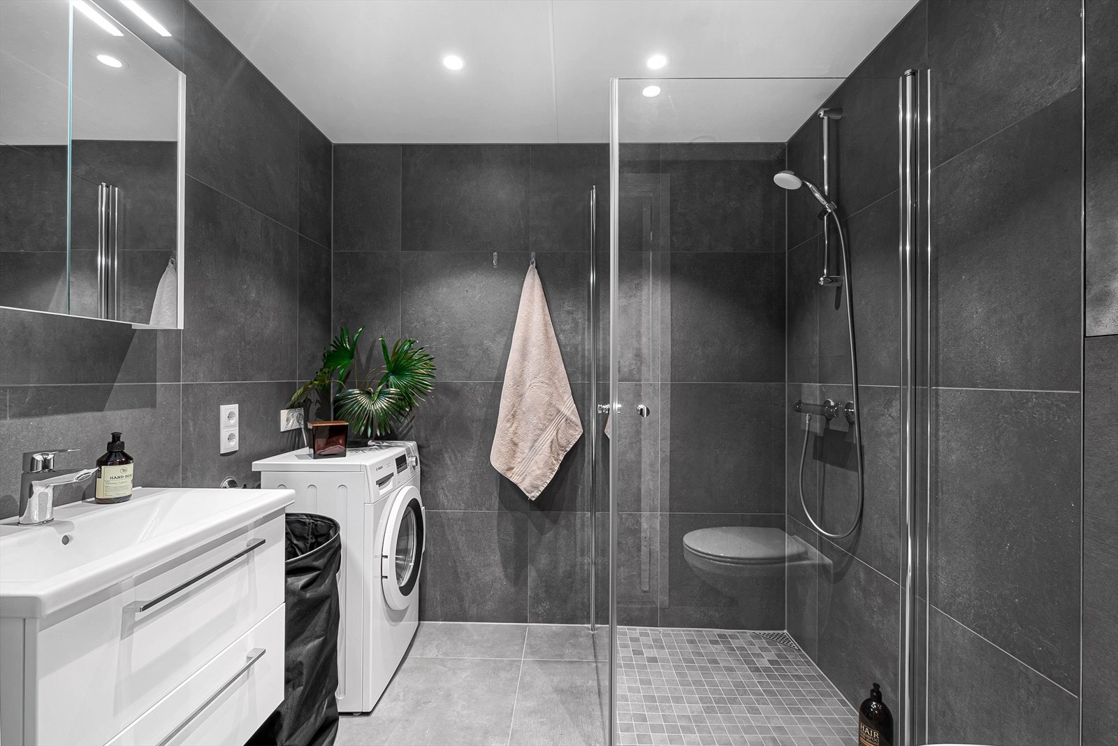 Badet har flislagte vegger og gulv som gir et stilrent og tidløst uttrykk. Galleribilde