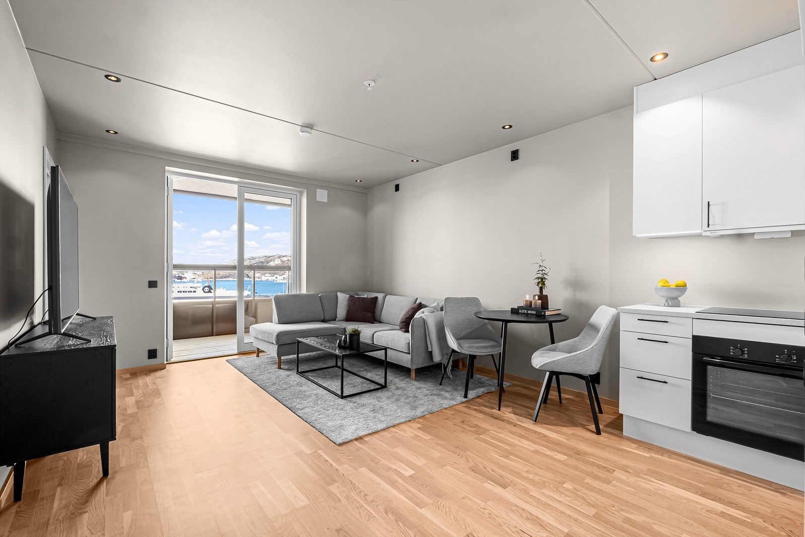 Stuen ligger i åpen løsning mot kjøkkenet og fremstår som lys og innbydende. Galleribilde