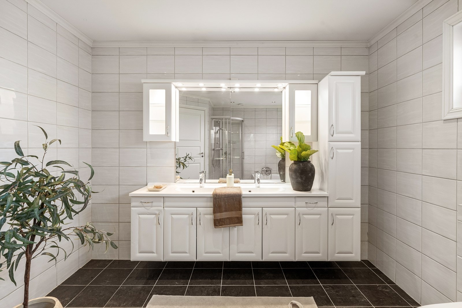 Mye oppbevaring gjør badet komplett. Et meget stort hovedbad med både badekar og dushjørne for store og små i en hektisk hverdag. Vindu for naturlig lys settes pris på av de som sminker seg. Galleribilde