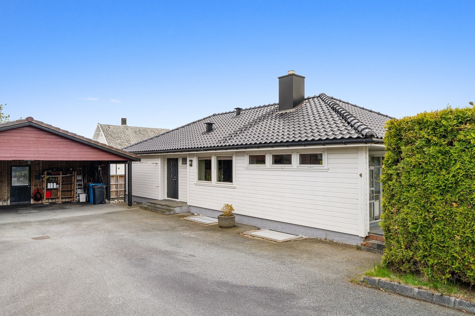 Plass til flere biler i asfaltert gårdsrom og god carport. (Carport er delt med nabo.) Sportsbod bak carport med god plass til lagring av sportsutstyr og annet. Utstyrt med arbeidsbenk. Galleribilde