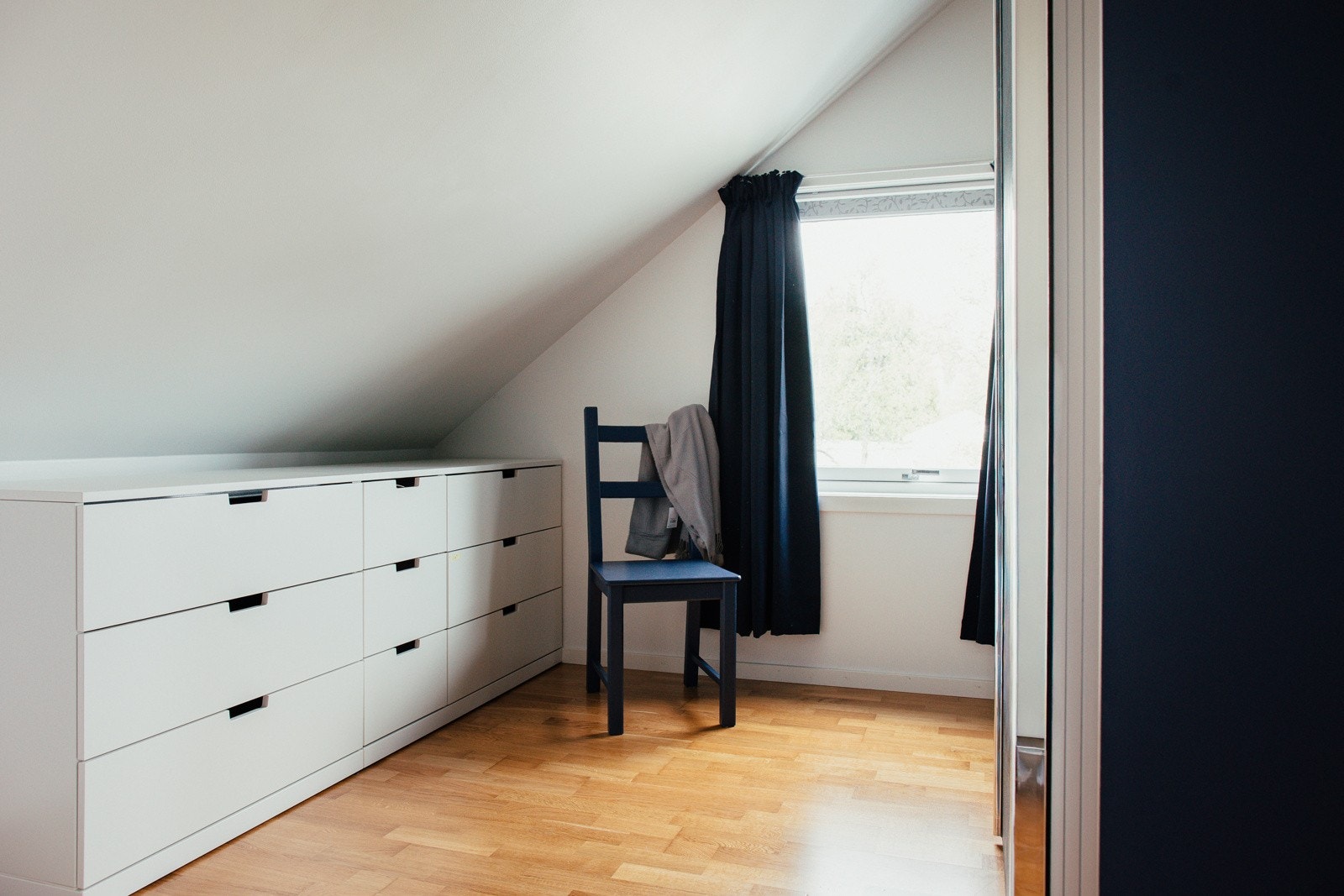 Soverom med parkettgulv, malte vegger og en praktisk skyvedørsgarderobe.  Selgers private foto