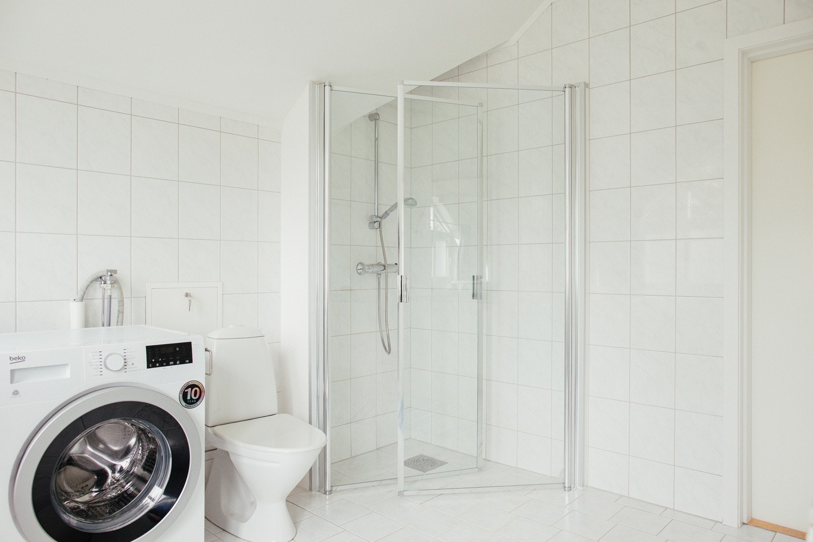 Badet har wc, opplegg for vaskemaskin og dusjhjørne med innfellbare glassdører fra 2019. Selgers private foto