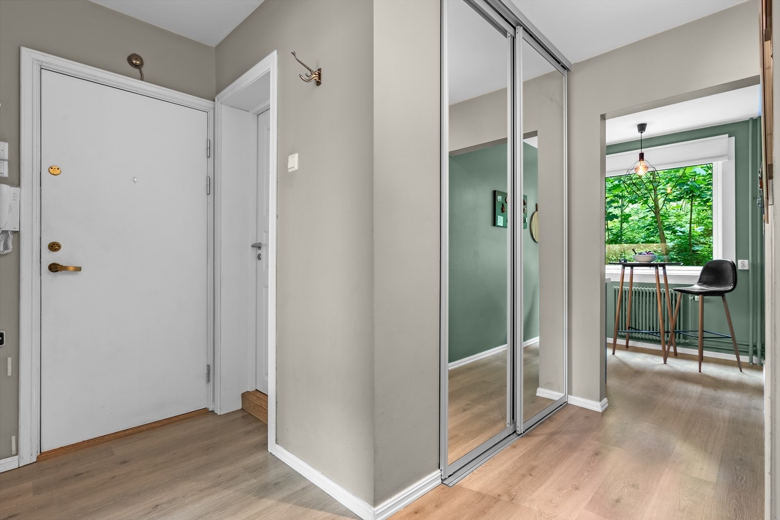 Entré med en romslig skyvedørsgarderobe med speilfronter. I skapet er det et praktisk opplegg for vaskemaskin og tørketrommel. Galleribilde