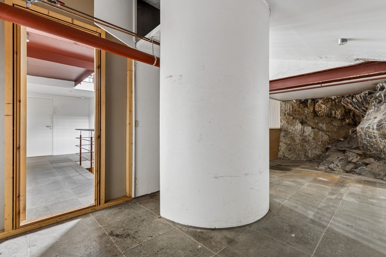 Bod til leiligheten. Særpregede detaljer i byggets fellesarealer, som eksponert fjell. Galleribilde