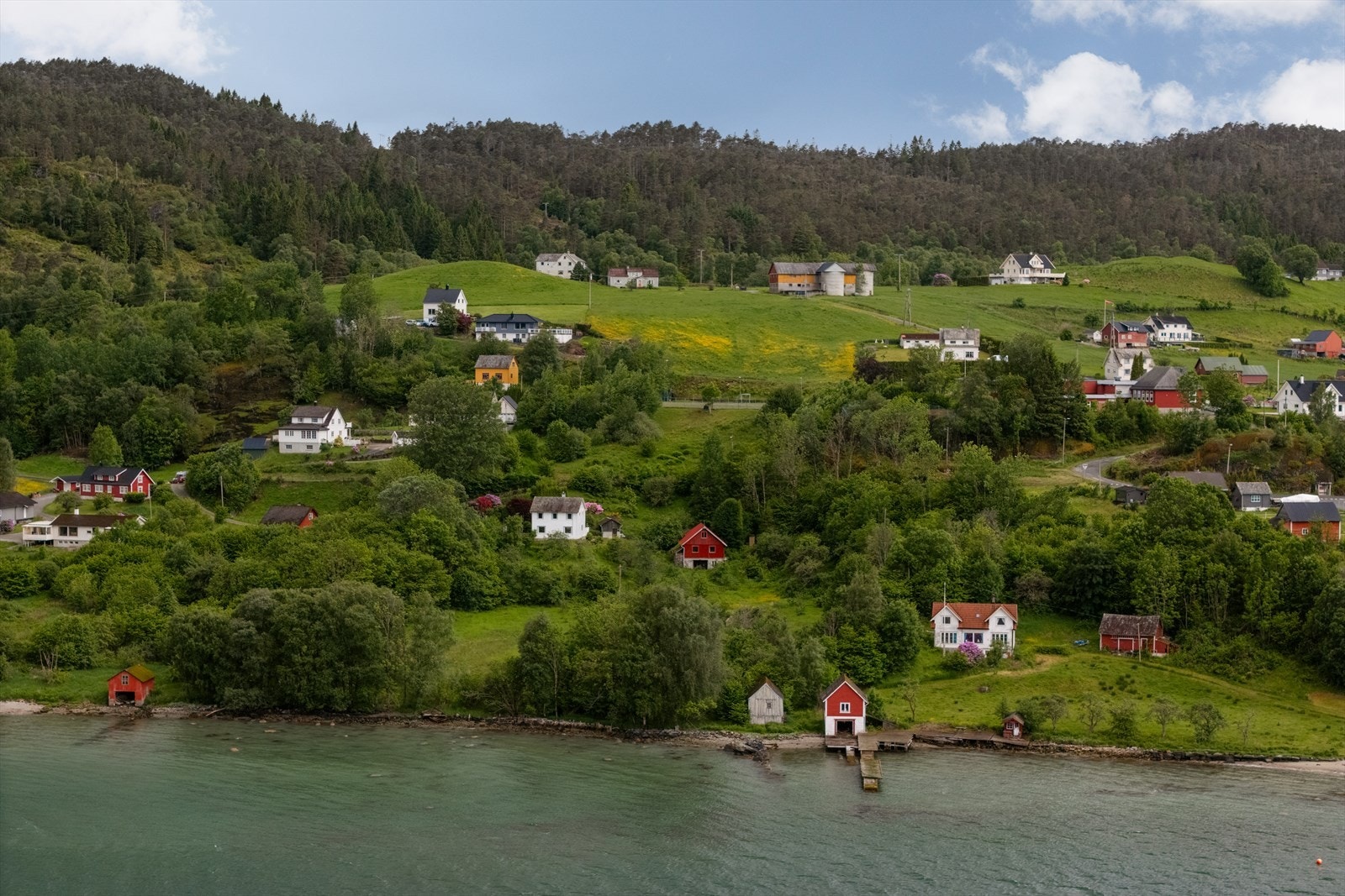Ved sjøen finner man et naust beliggende helt i strandkanten. Galleribilde