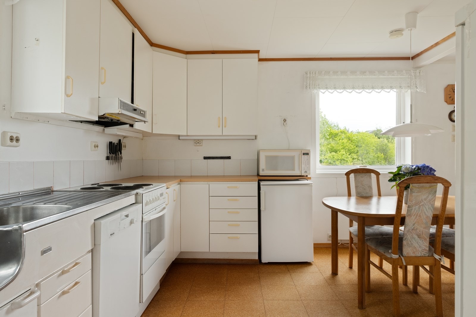 Kjøkkenet ligger i tilknytning til stuen og har slette fronter, laminat benkeplate og standard hvitevarer som oppvaskmaskin, kjøleskap og komfyr. Galleribilde