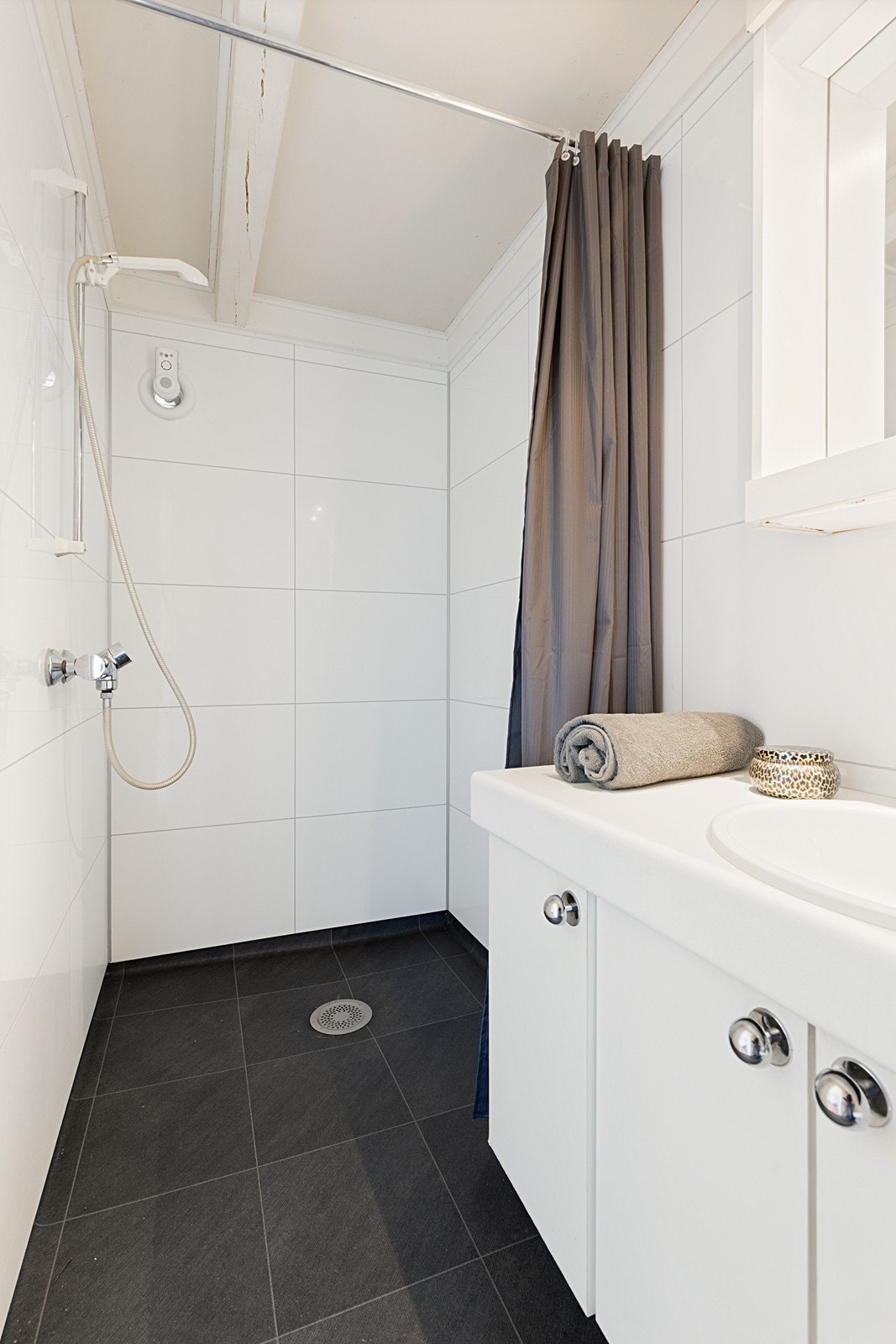 Badet er pusset opp i nyere tid, og er utført tidløst med hvite vegger og mørke gulv. Galleribilde