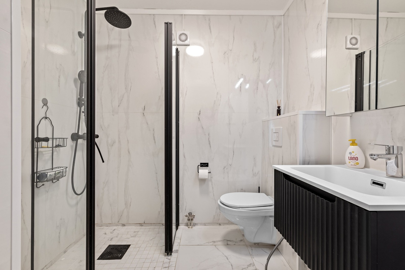 Badet i hovedetasjen er innredet med servantinnredning, vegghengt toalett og dusjløsning, samt flislagt gulv med varmekabler. Galleribilde