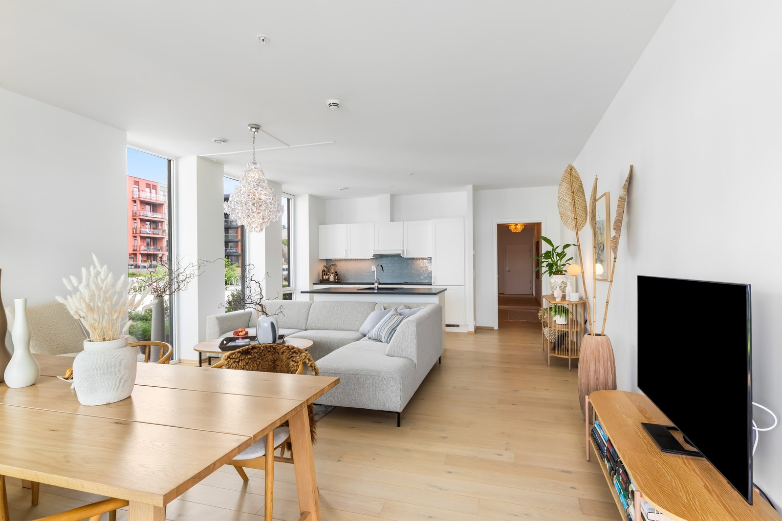 Stuen har god plass til både sofagruppe og spisebord, med parkettgulv og malte veggflater. Galleribilde