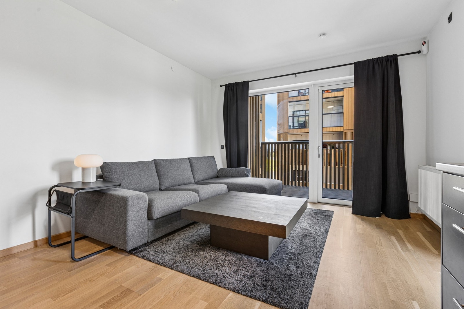 Stue i åpen løsning mot kjøkkenet, med plass til både sofagruppe og spisebord Galleribilde