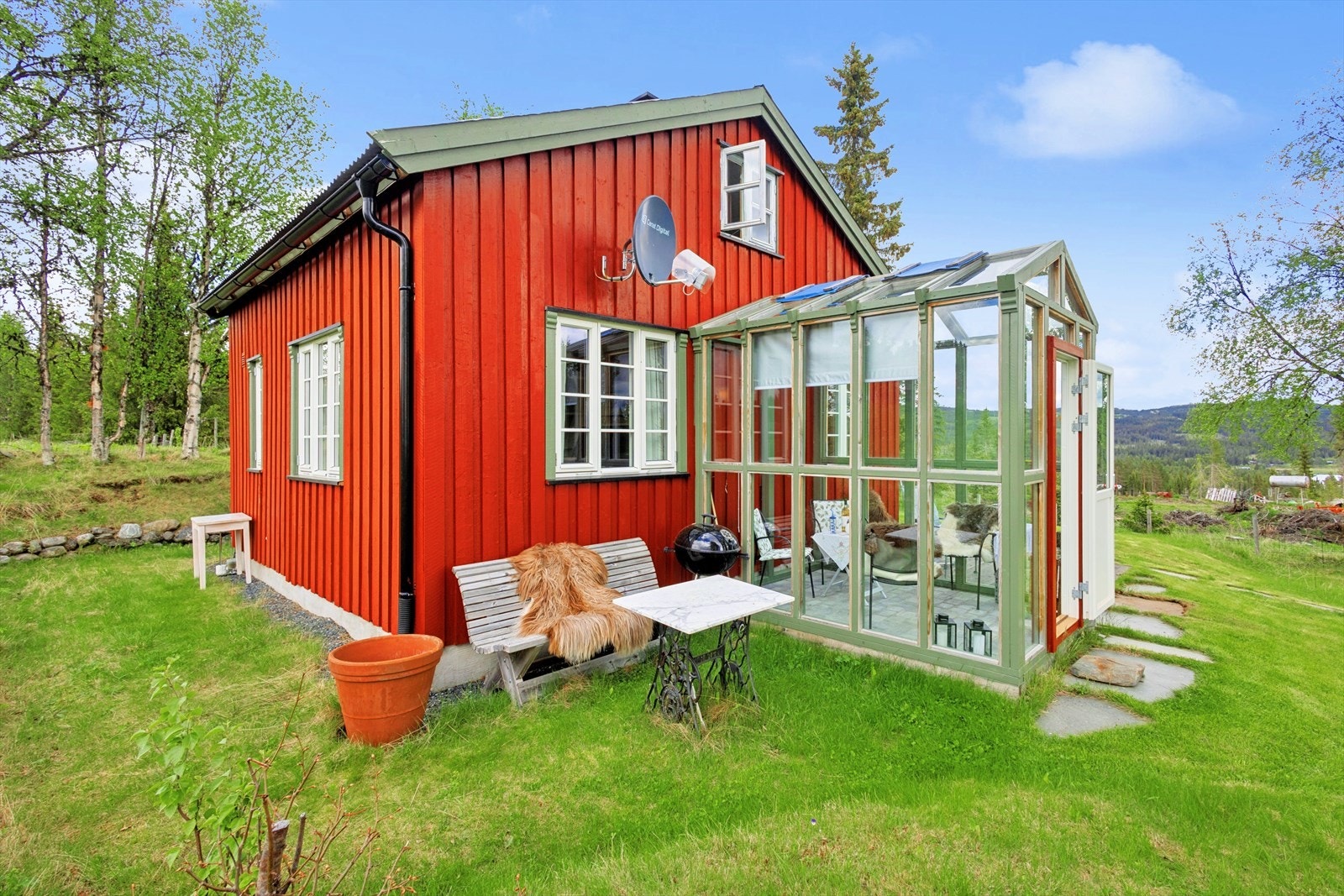 Tomten er en naturtomt som ligger i hellende terreng på en naturlig kolle. Her er kveldssol- plassen før man kan trekke inn i lysthuset! Galleribilde